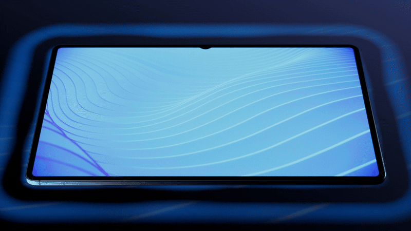 Close-up of a modern smartphone with a blue abstract digital wallpaper on its screen, lying on a dark surface.