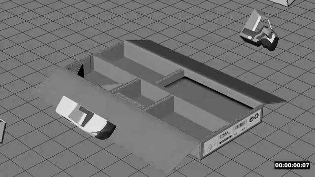 3D model layout of a small building with walls and interior spaces, along with two remote controls on a grid-patterned surface.