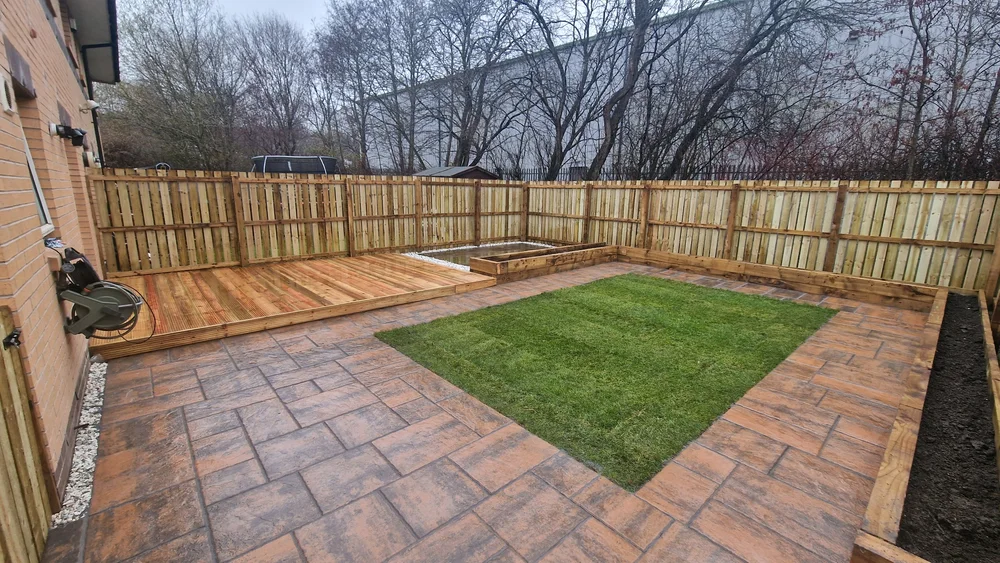 Concrete paving beside a timber deck and garden lawn