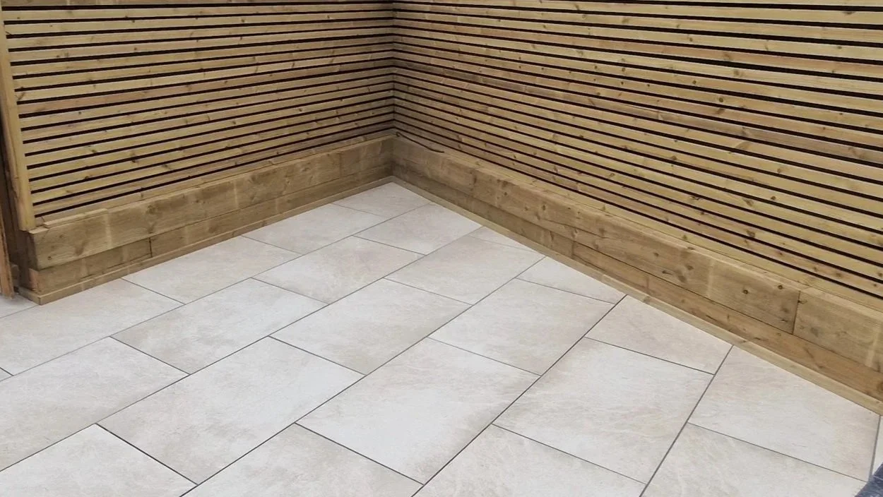 Light porcelain paving beside timber garden fencing