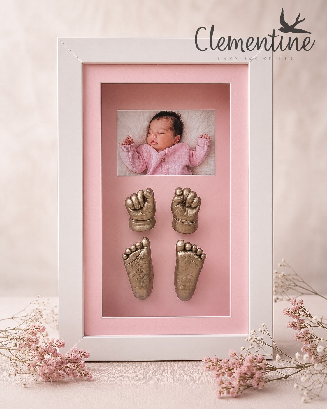 German Silver baby hand and foot castings displayed in a white shadow box frame with a pink mount and newborn photo — a personalised baby keepsake by Clementine Creative Studio, New Zealand.