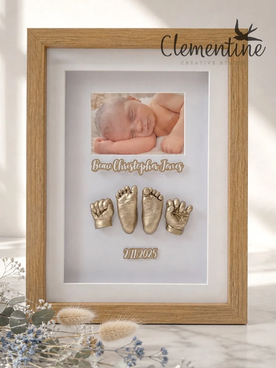German Silver baby hand and foot castings in a portrait oak shadow box frame with a newborn photo and personalised name plaque — handcrafted by Clementine Creative Studio, New Zealand.