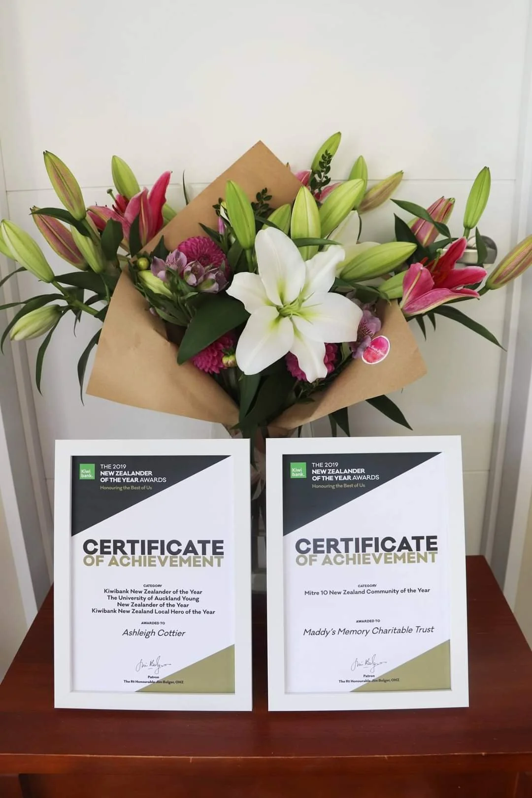 Ashleigh Cottier and Maddy's Memory Trust 2019 Kiwibank NZ of the Year certificates with flower bouquet