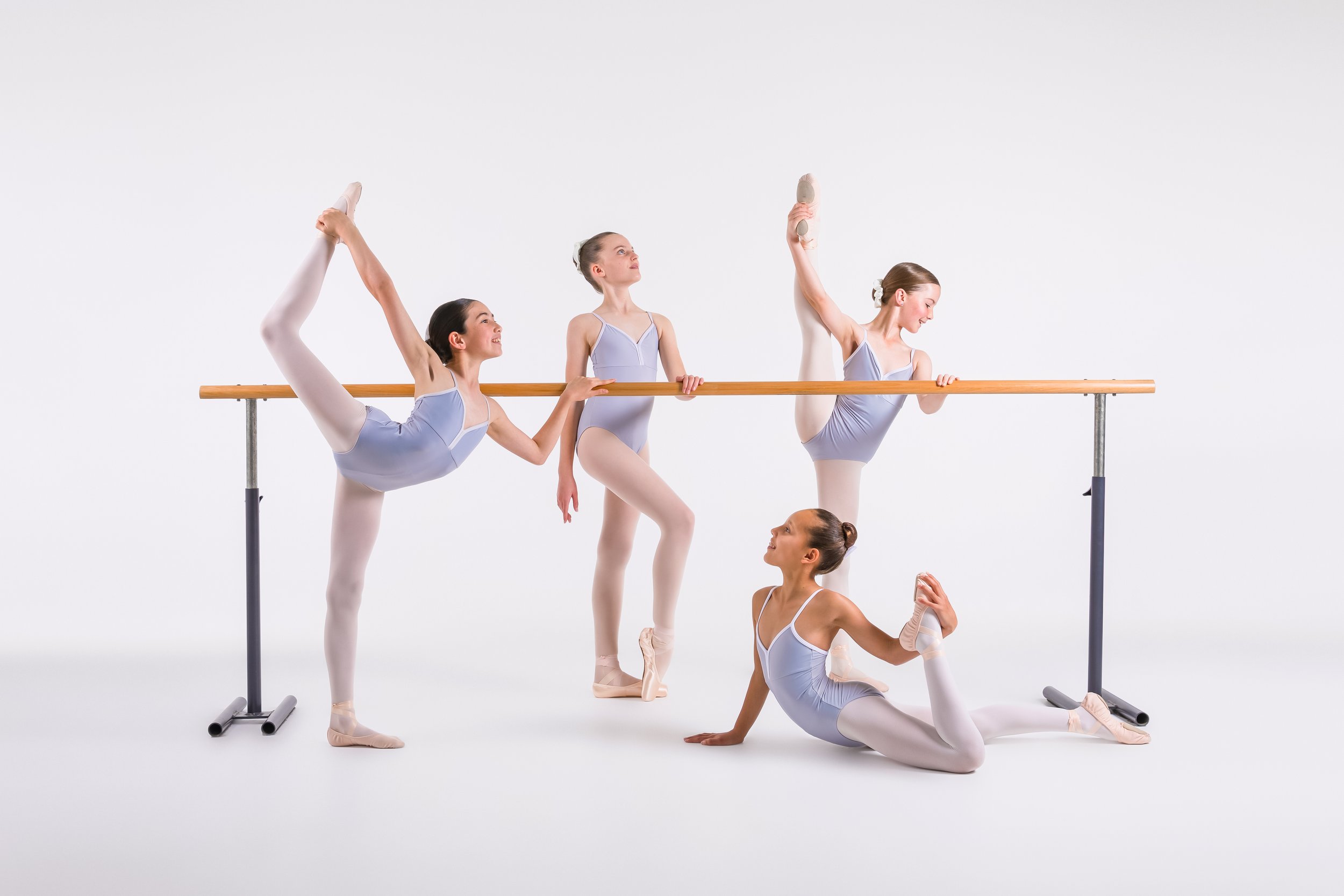 Ballet class practising flexibility and technique at the barre at Shire Ballet Academy.