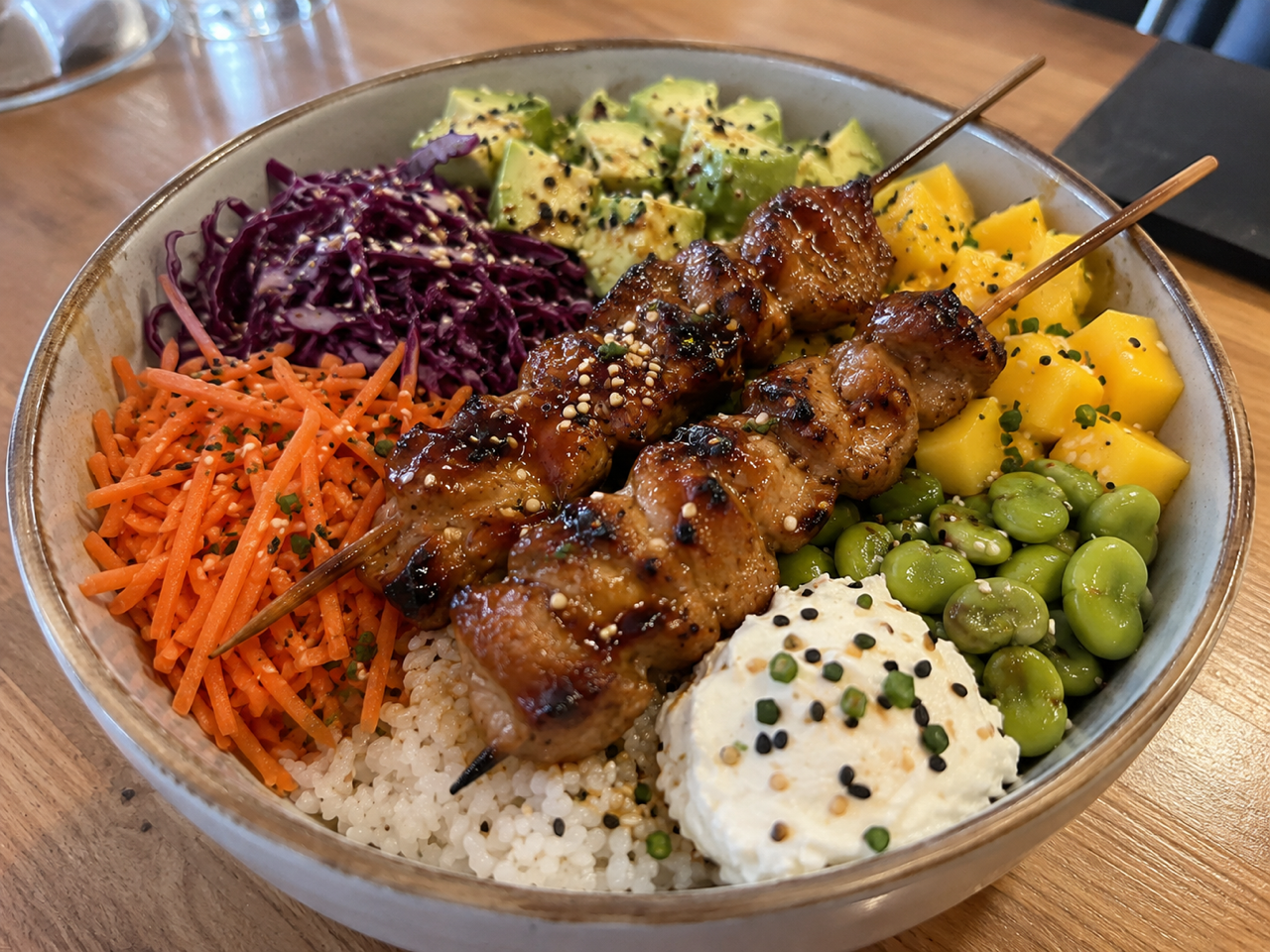 Poké Yakitori : brochettes Yakitori, riz vinaigré, carottes, chou rouge, avocat, fèves, mangue, cream cheese, sauce teriyaki