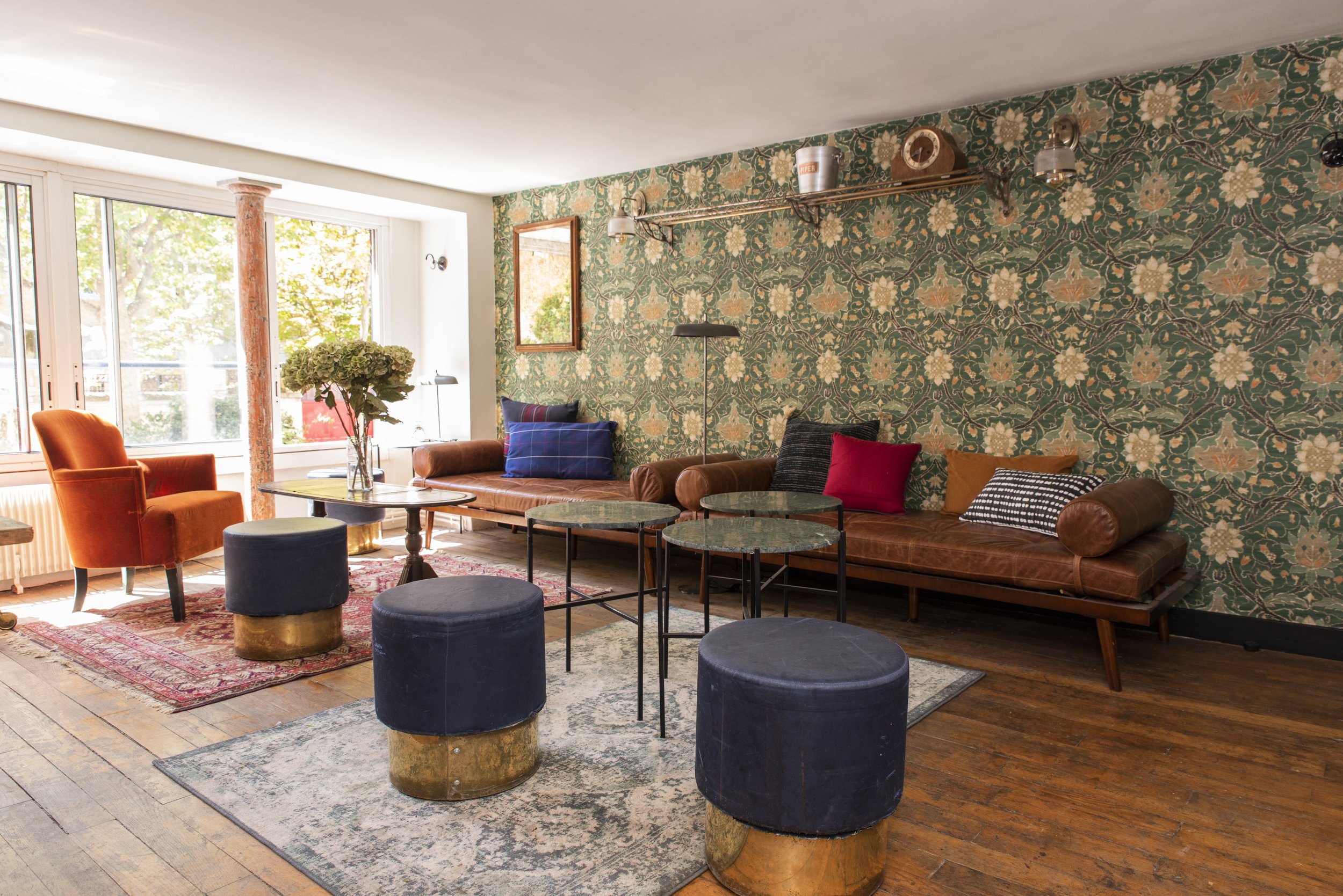 grande salle cosy avec des canapés, fauteuils et tabourets pour s'asseoir entre amis ou en famille, décoration vintage