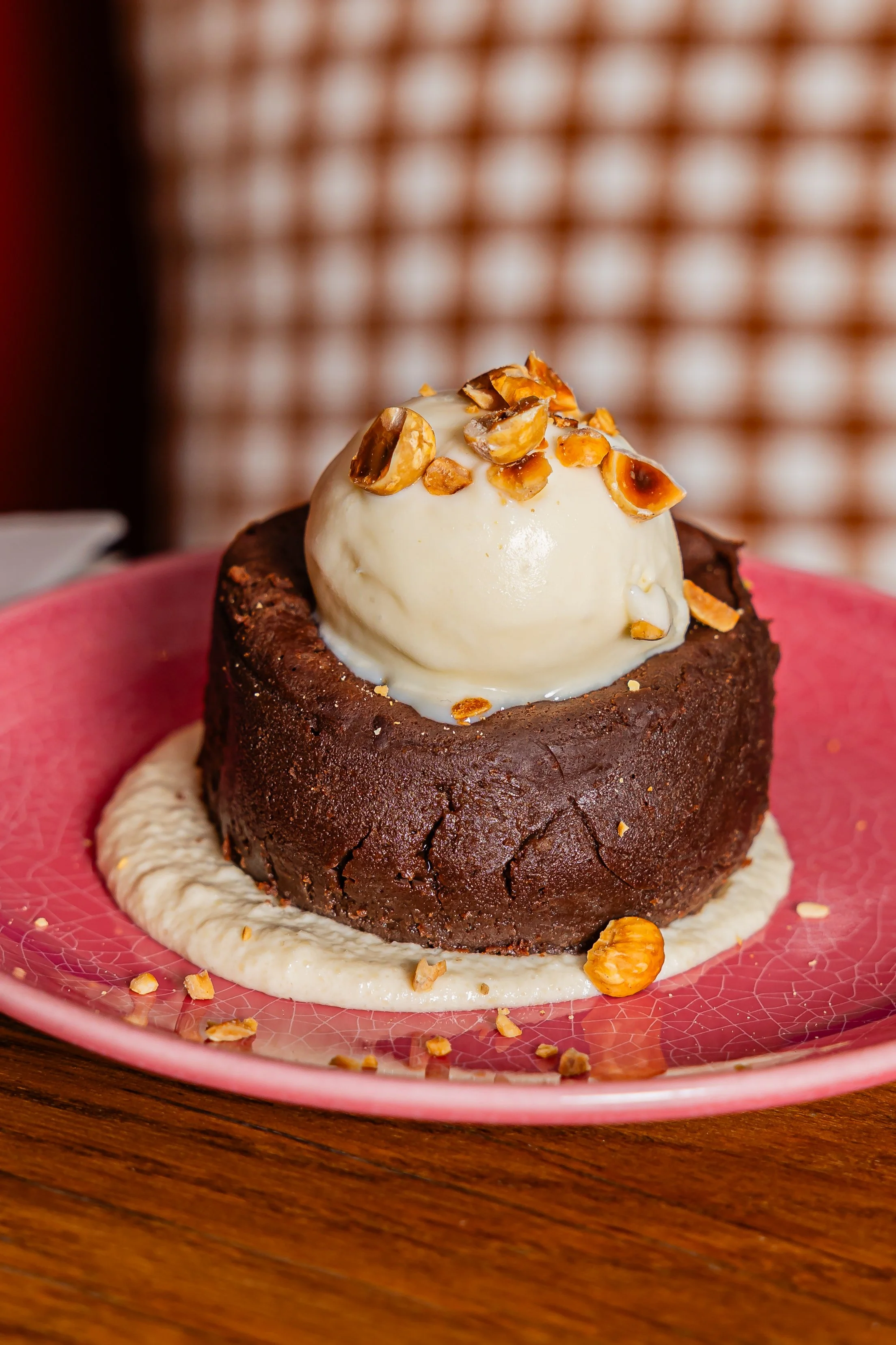 Un moelleux au chocolat avec une boule de glace sur une assiette rose