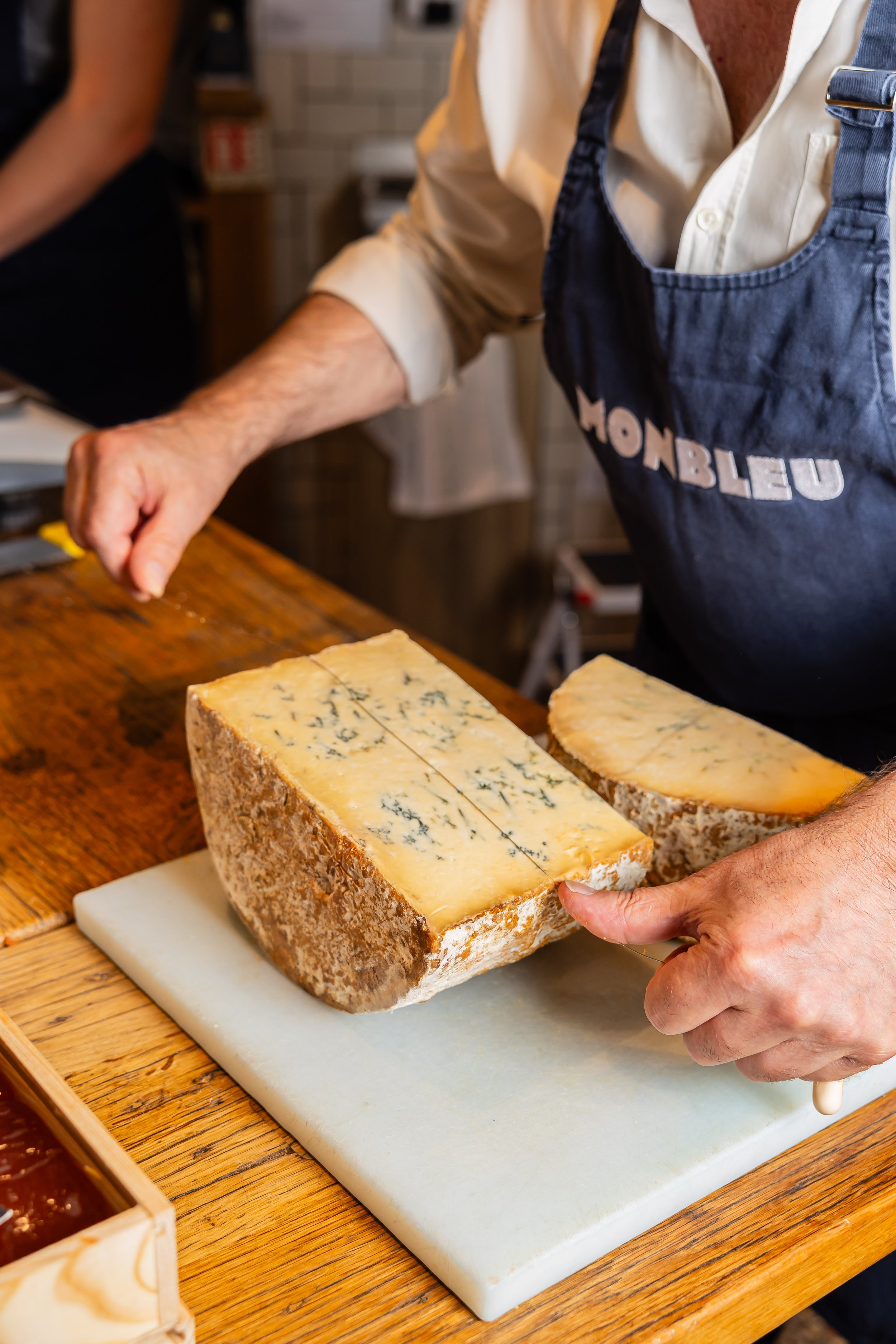Un fromage est découpé au fil par un de nos fromager