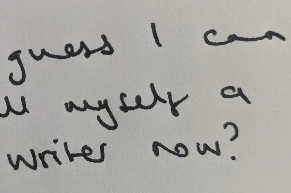 Close-up of handwritten note on white paper asking, "Guess I can you my letter a writer now?"