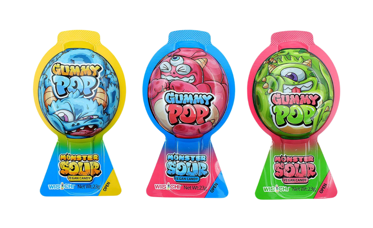 Three colorful gummy candy packages shaped like monsters with cartoon monster illustrations on the wrappers. The packages are yellow, blue, and pink, each labeled "Gummy Pop" and "Monster Sour Vegan Candy," with a net weight of 23 grams.