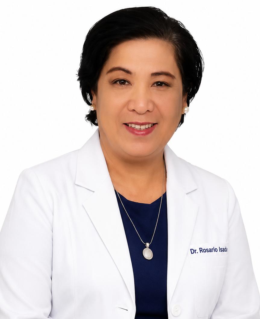 Portrait of a woman with short black hair, wearing pearl earrings, a navy blue top, a silver necklace, and a white lab coat with the name Dr. Rosario Isada embroidered on it, against a white background.