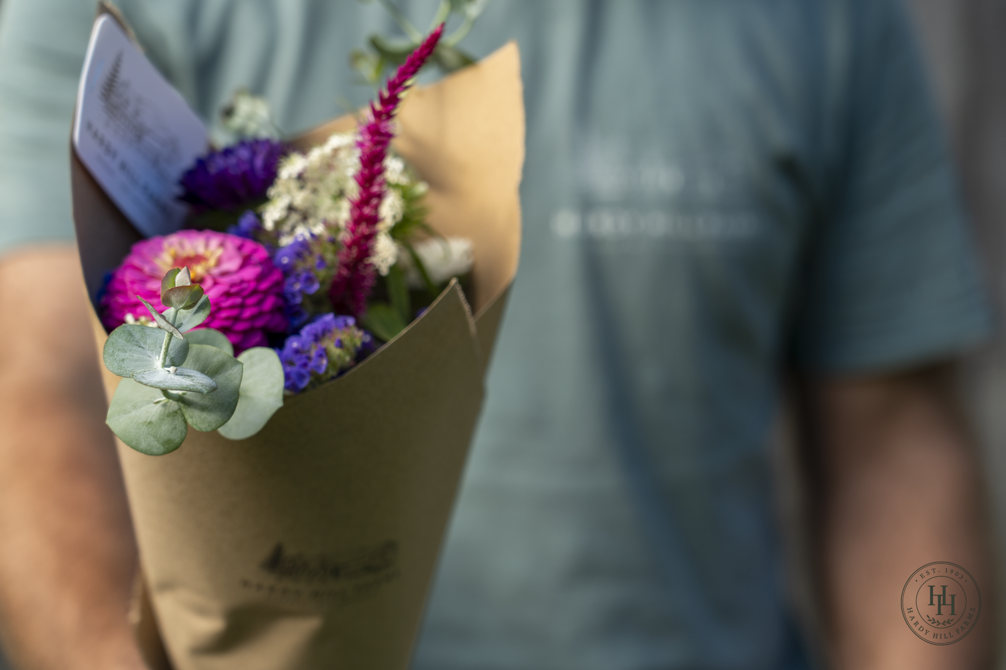 A farmer holding a bouquet of mixed flowers