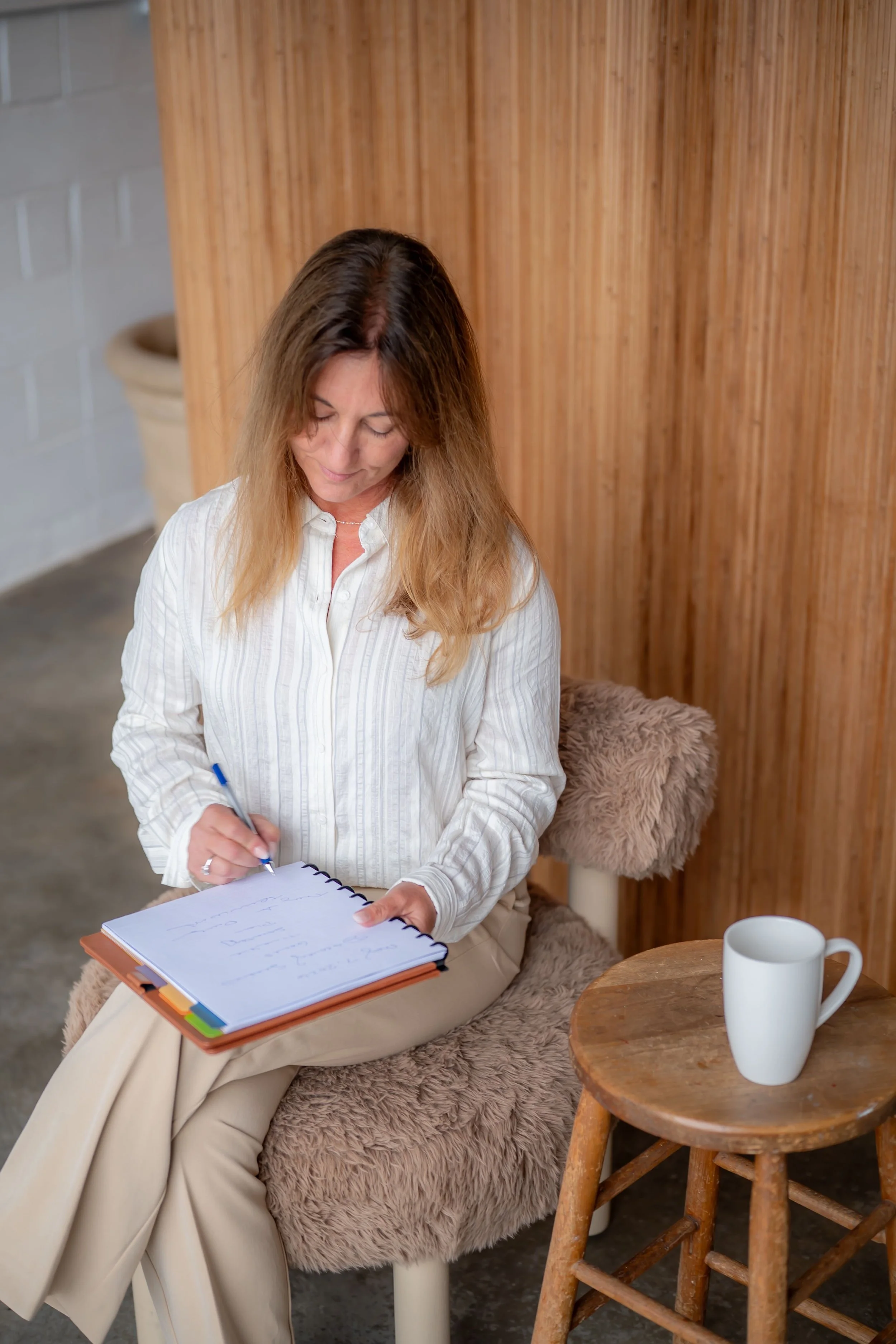 Business woman writing in planner while sitting in a chair