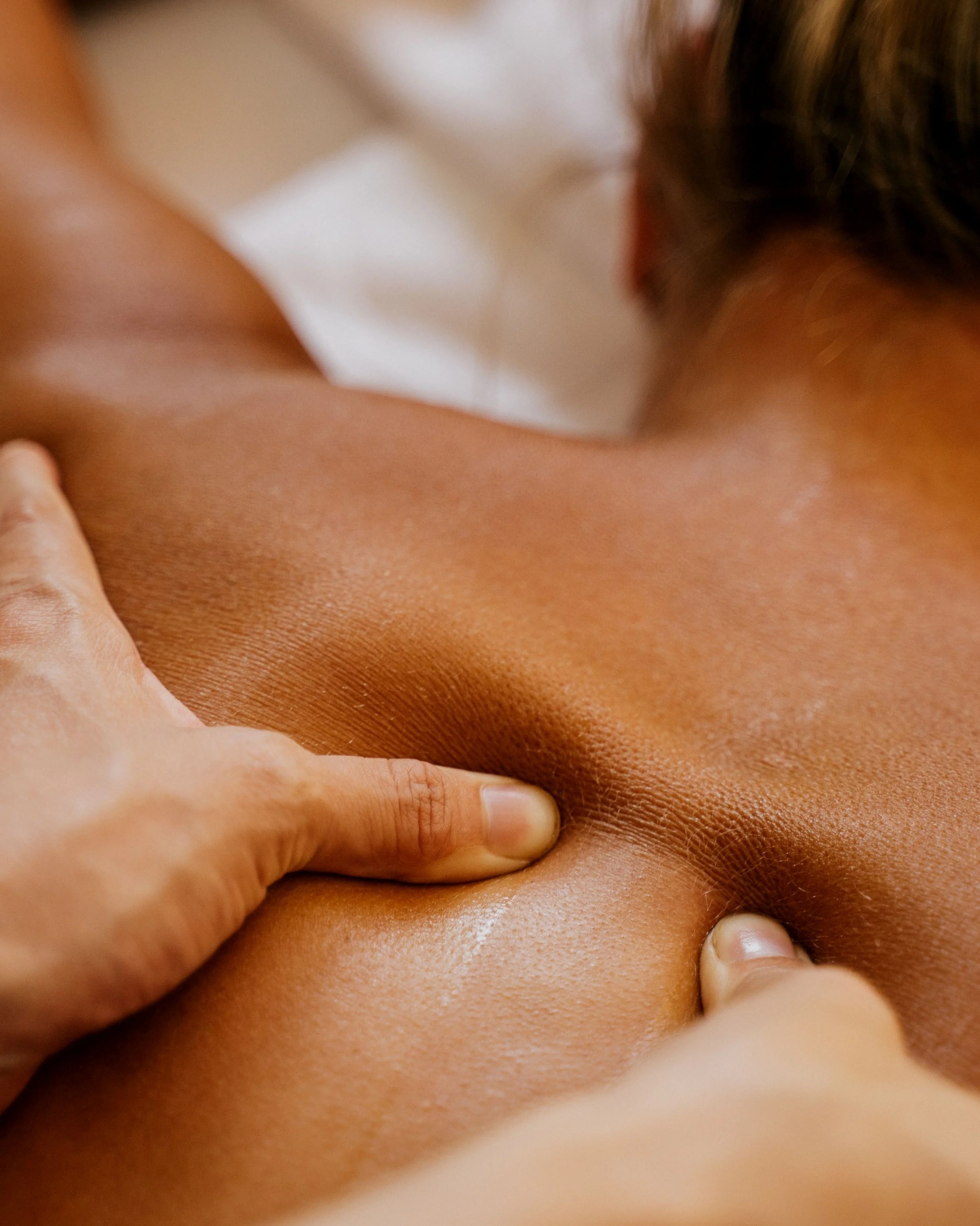 Close-up of person’s skin with fingers pressing on it, showing skin texture and natural skin tone.