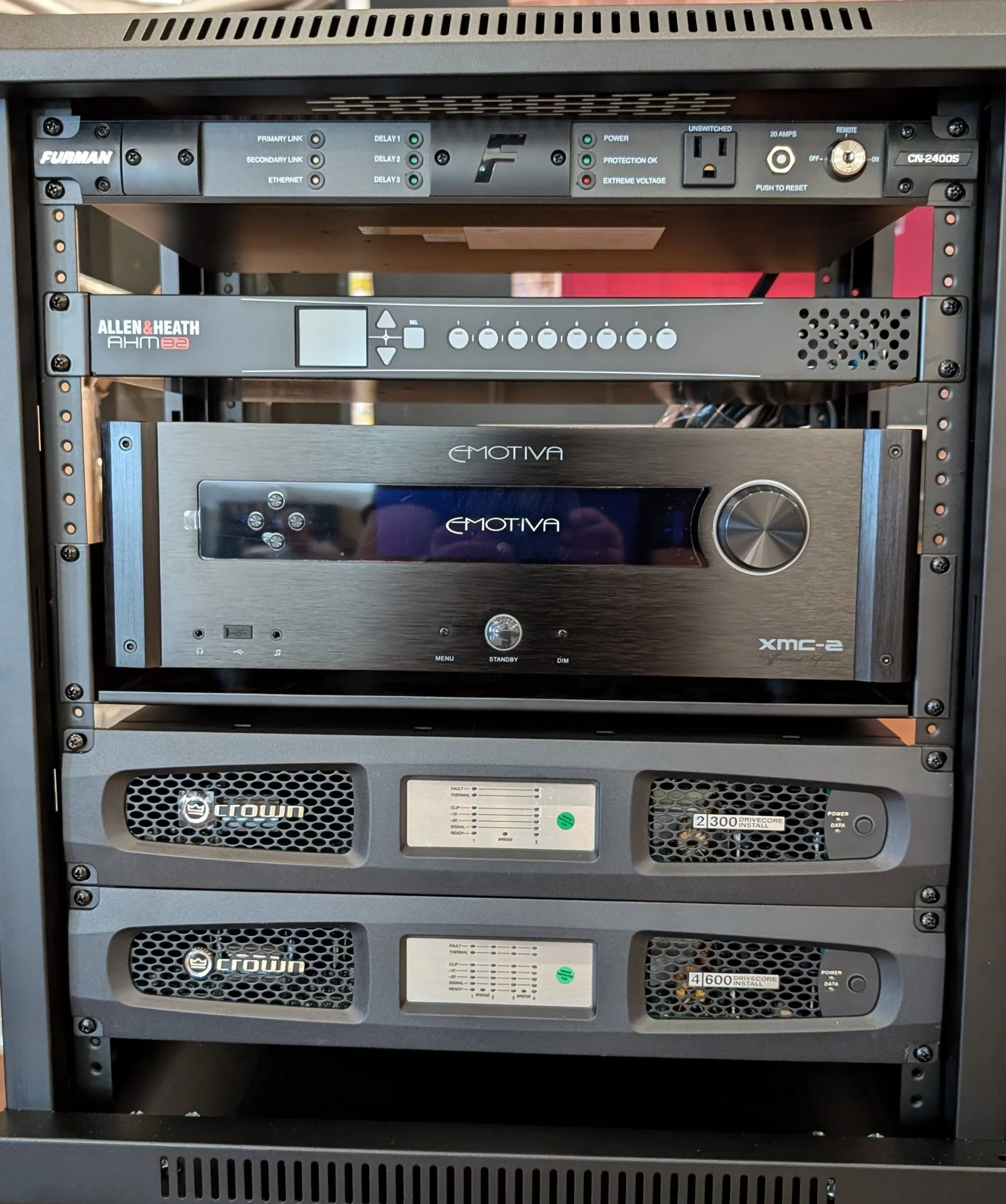 Equipment rack with various audio and power components, including Crown power amplifiers, Allen & Heath audio processor, and Furman power conditioner.