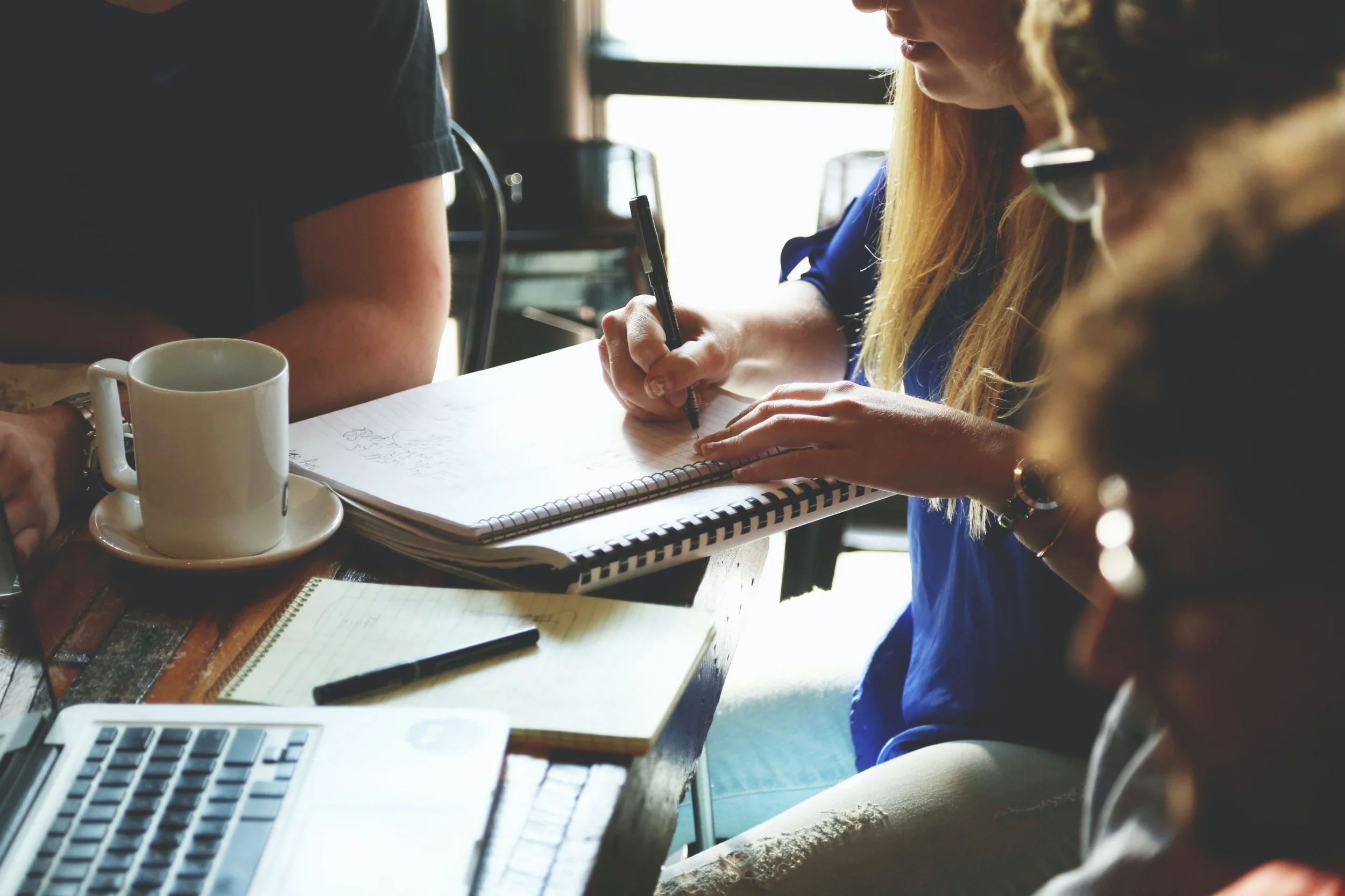 woman making notes while another person watches