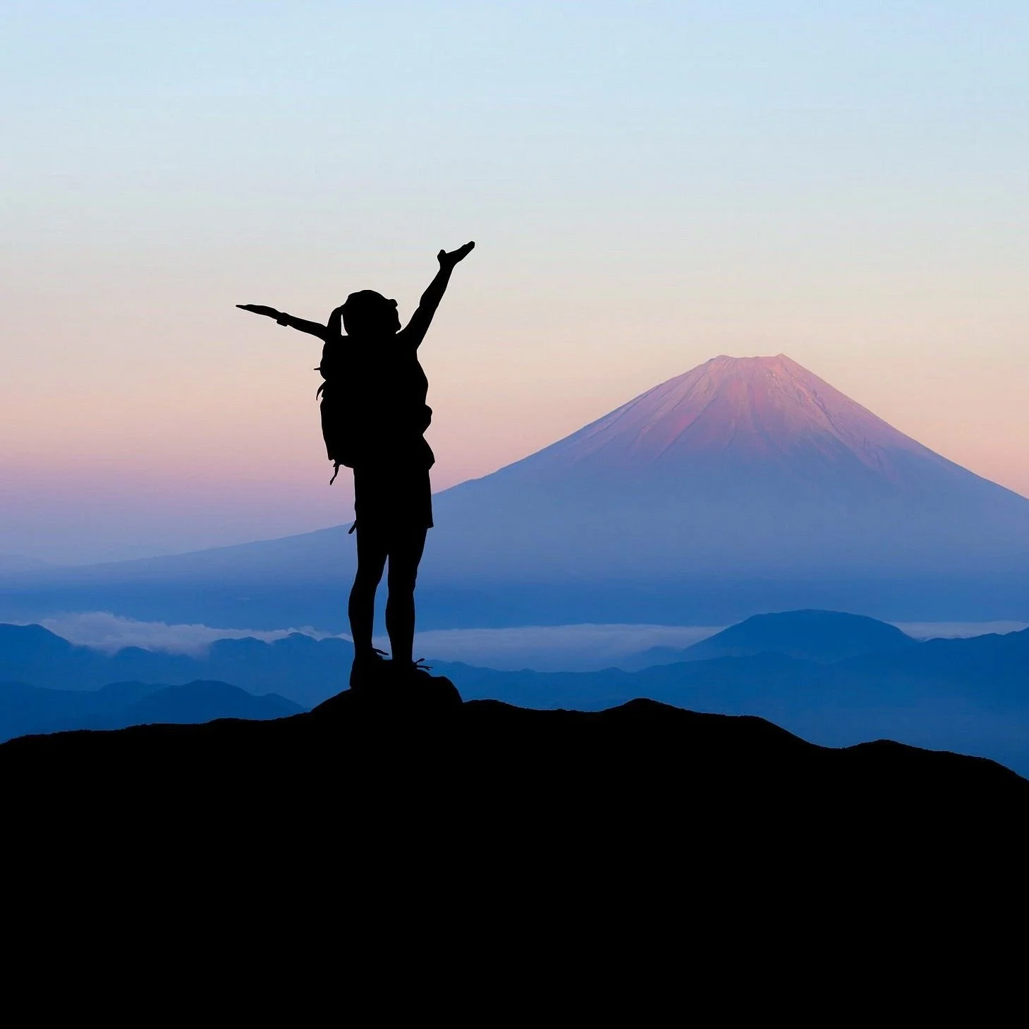 Woman with arms outstretched, on mountain