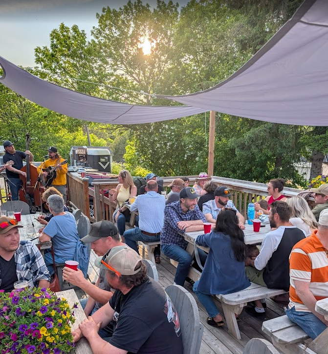 Image of people sitting on the deck listening to music.