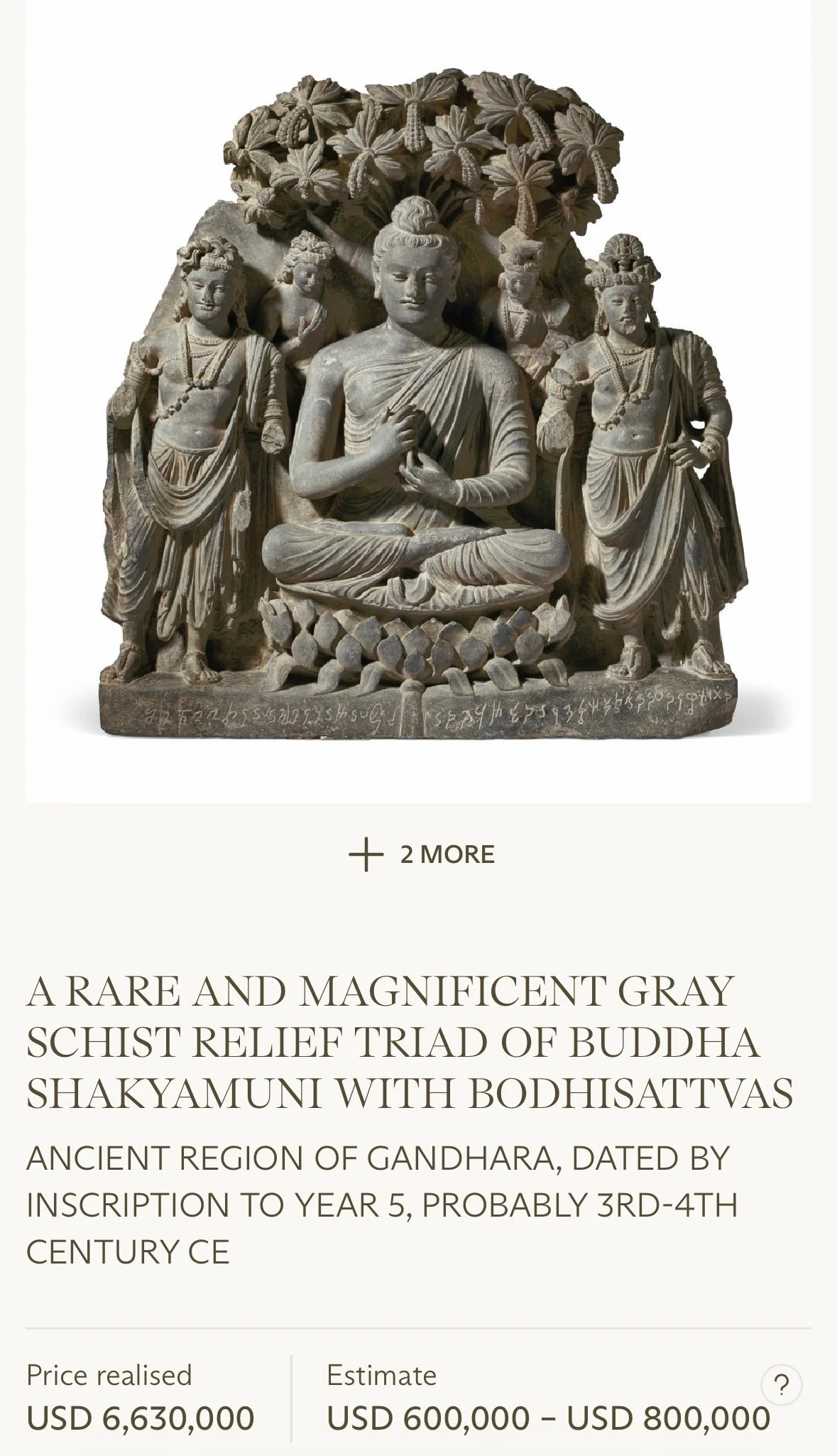 Gray stone relief sculpture depicting Buddha in meditation surrounded by attendants and decorative elements, with inscriptions at the base.