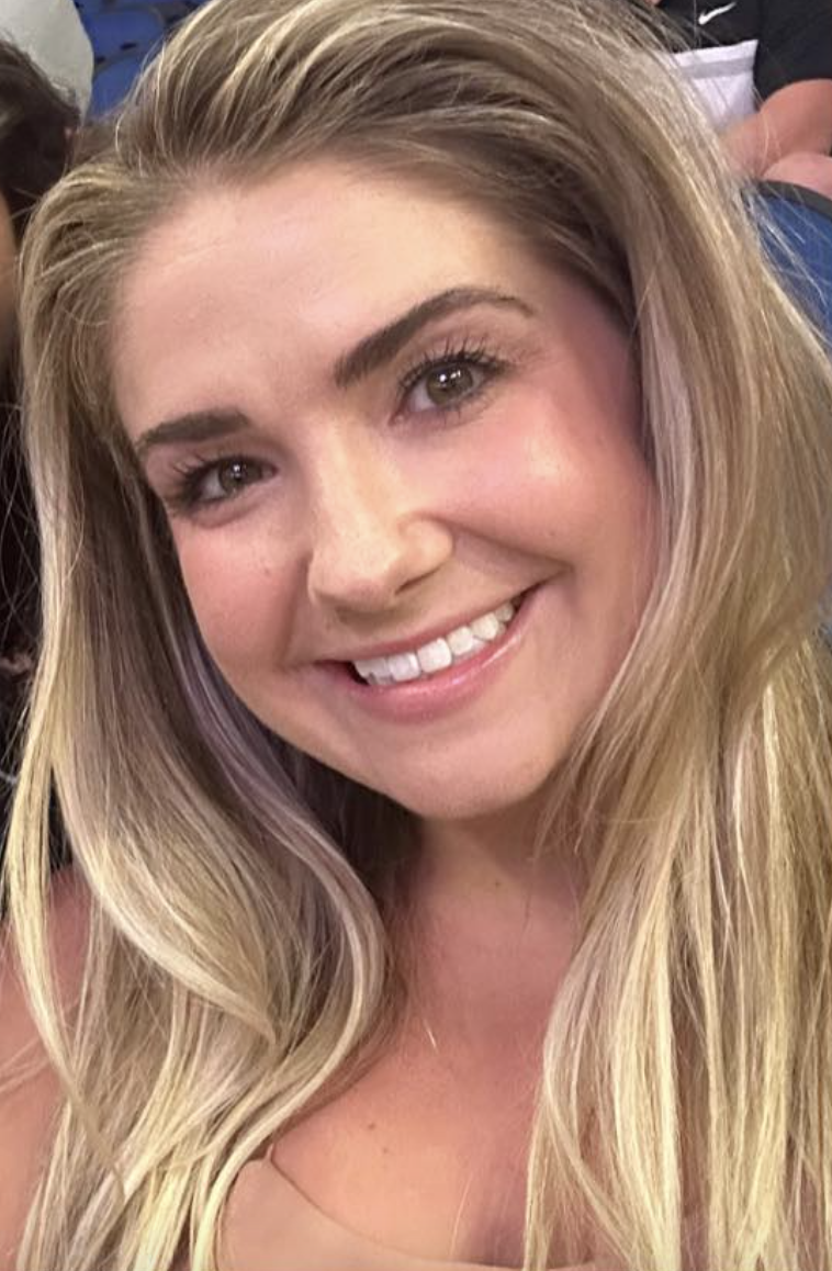 Close-up of a smiling young woman with long blonde hair and brown eyes.