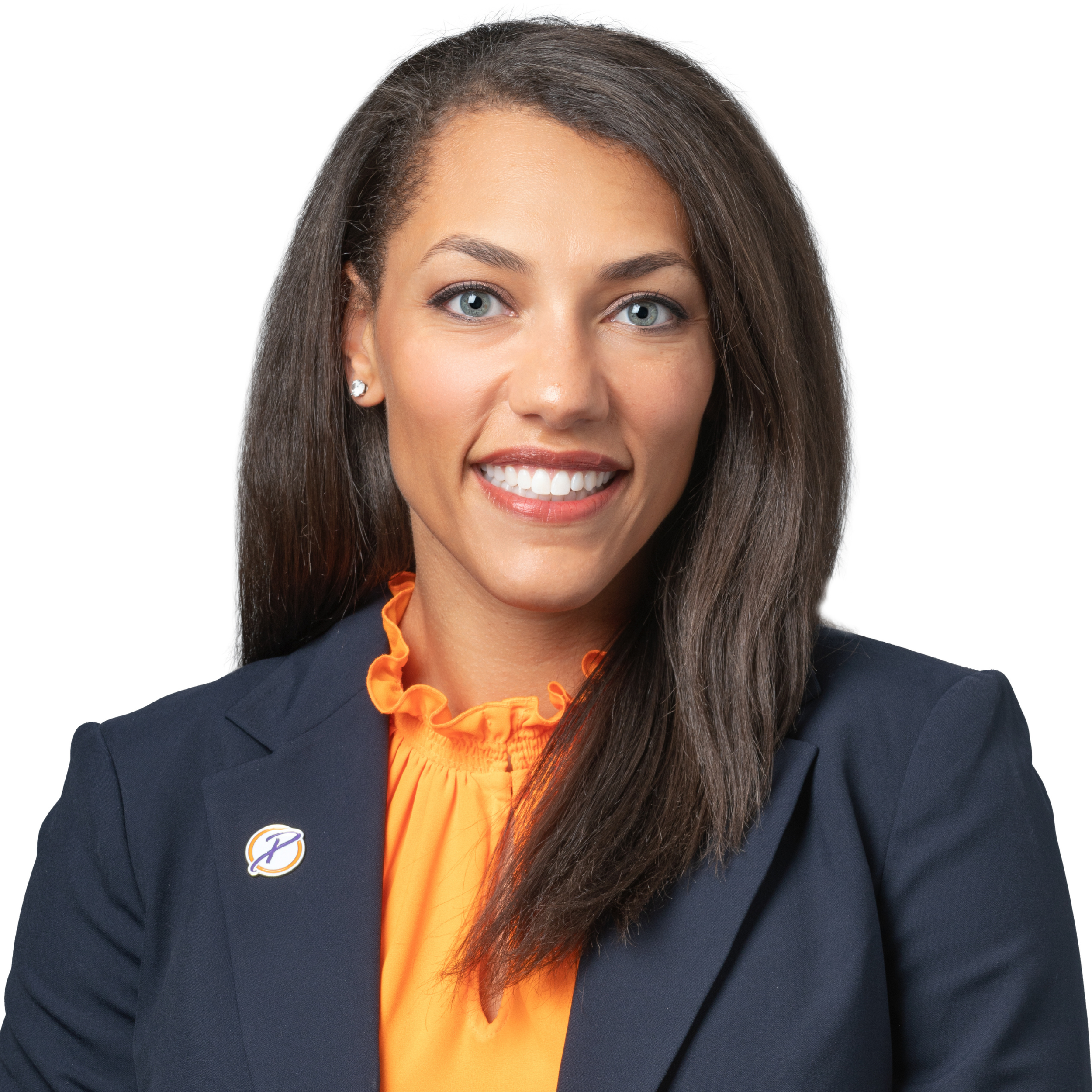 A professional smiling Bi-racial woman with long wavy brown hair, wearing a pink sweater and a dark jacket with a Pat Summitt Foundation lapel pen, against a white background.