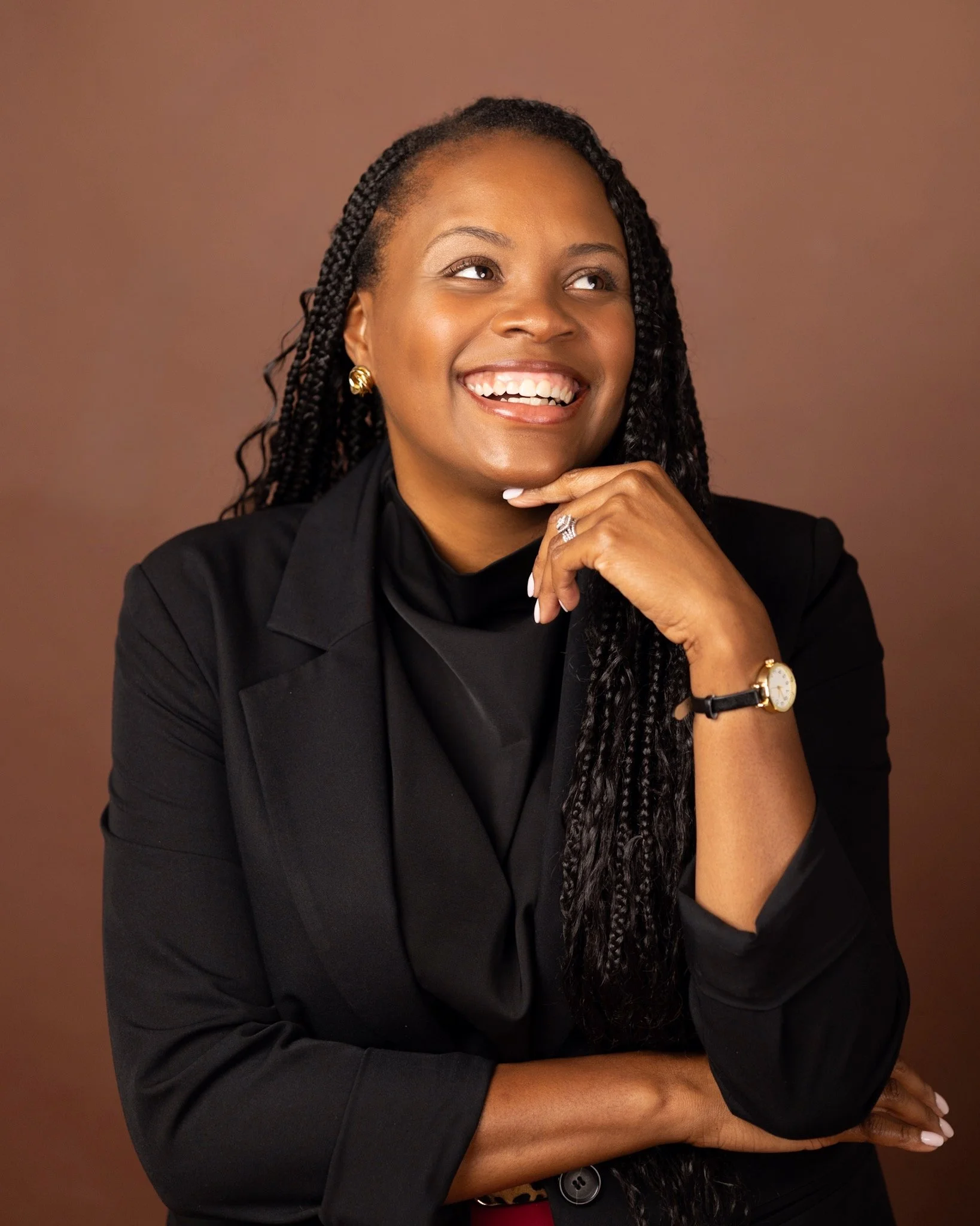 A smiling woman with hand on her chin smiling