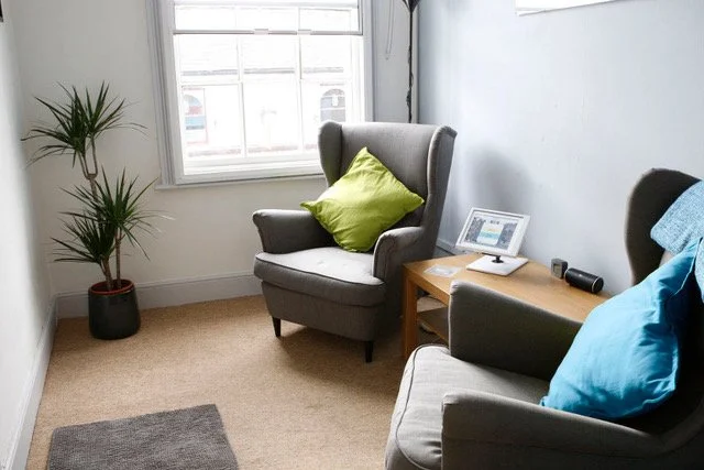 A therapy room with a chair by a window