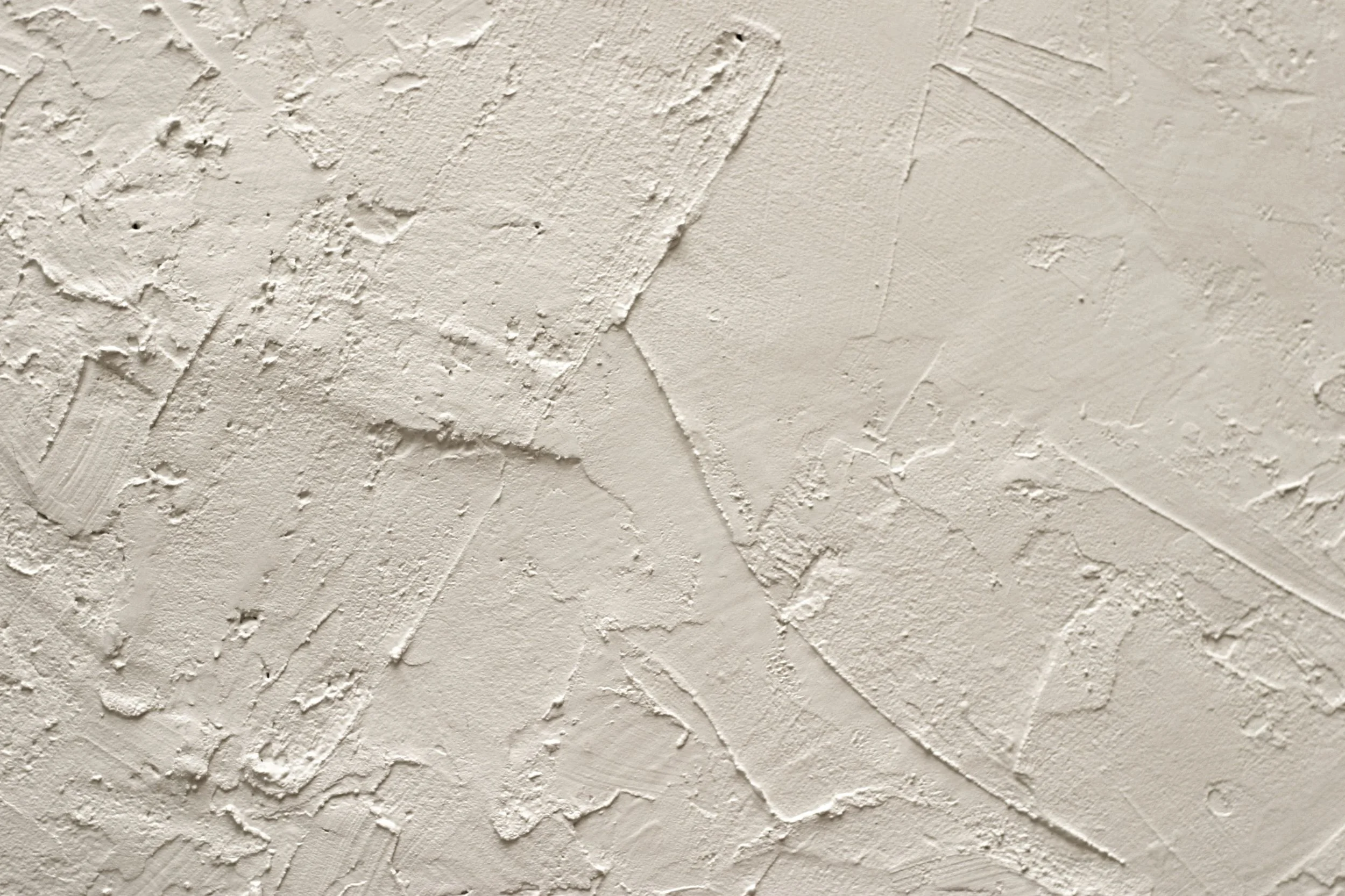Surface en plâtre ou en texture artistique murale avec des motifs et des couches en relief variées.
