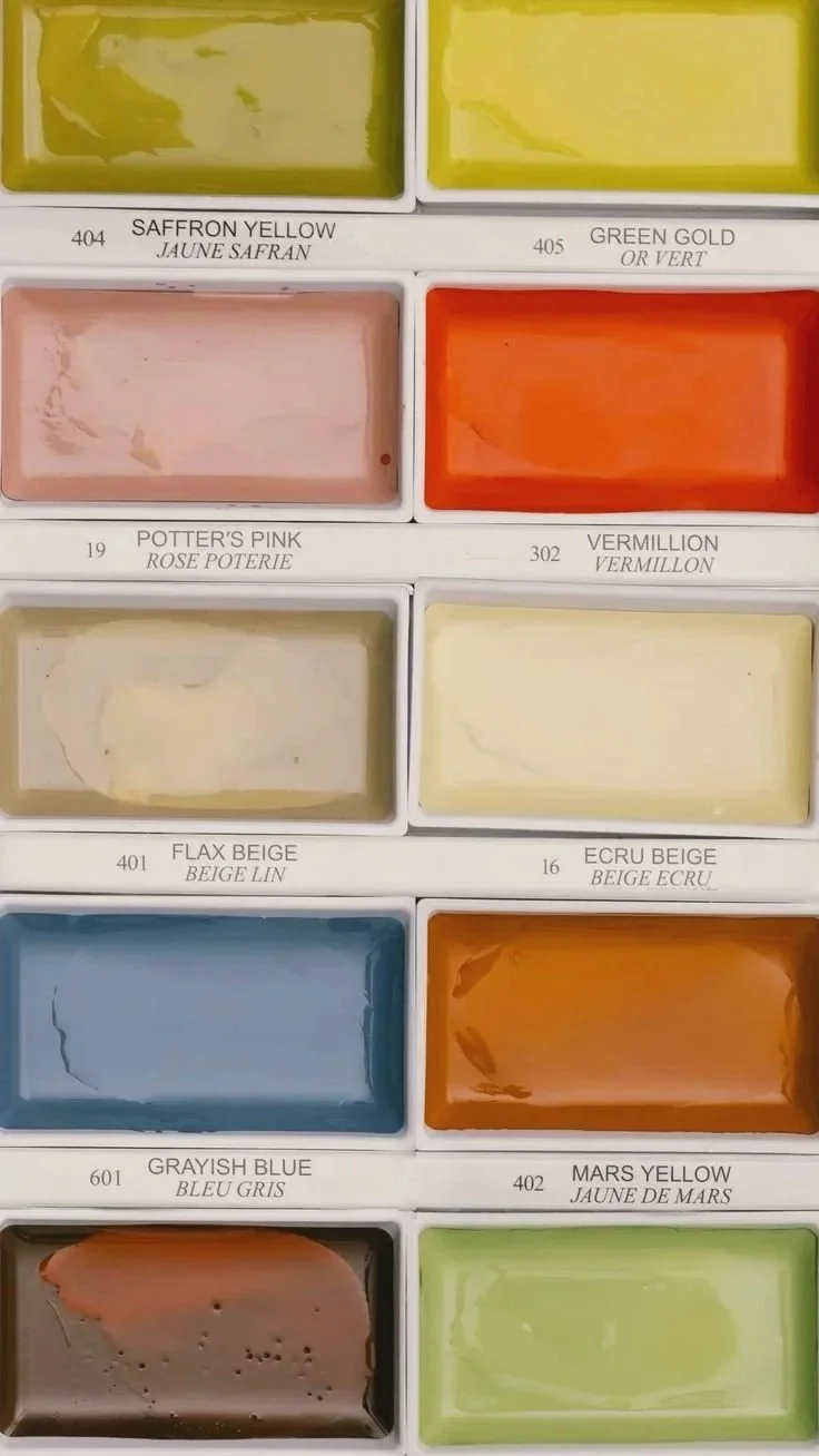 Palette de peintures avec des couleurs variées, y compris jaune safran, vert or, rose Potter's Pink, vermillon, beige lin, beige écru, bleu gris, jaune de Mars, brun et vert clair.