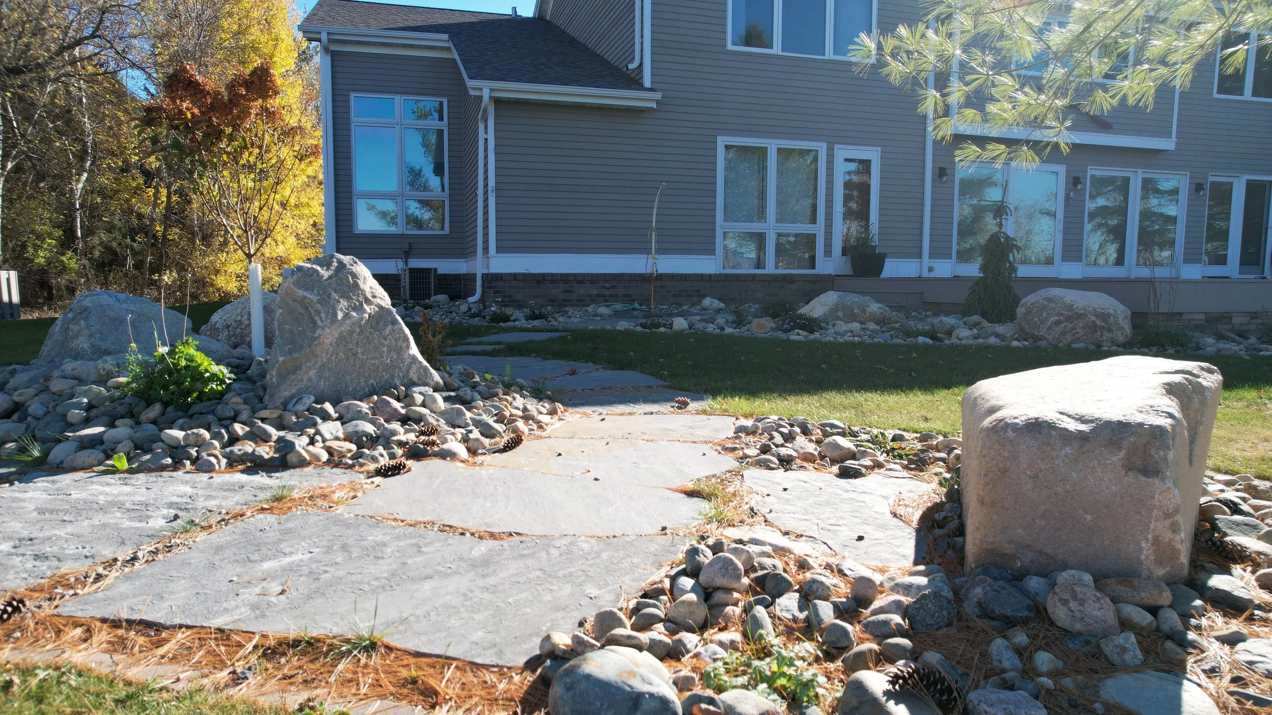 Sitting Rock Island Foundational Landscaping, with Large Flagstone Pathway, Ornamental Trees selectively placed within the Rock Gardens