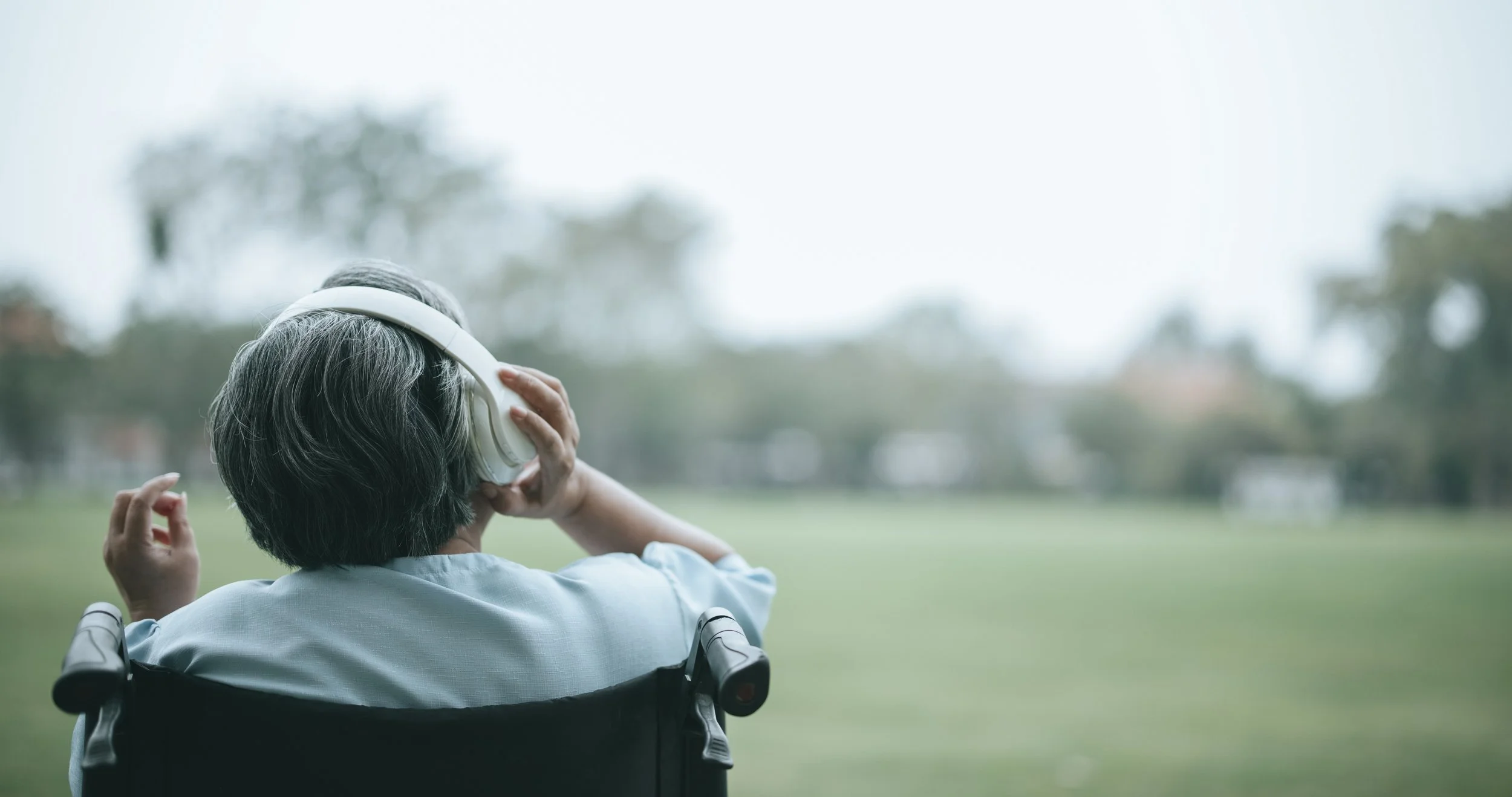 Woman wearing headphones, in wheelchair