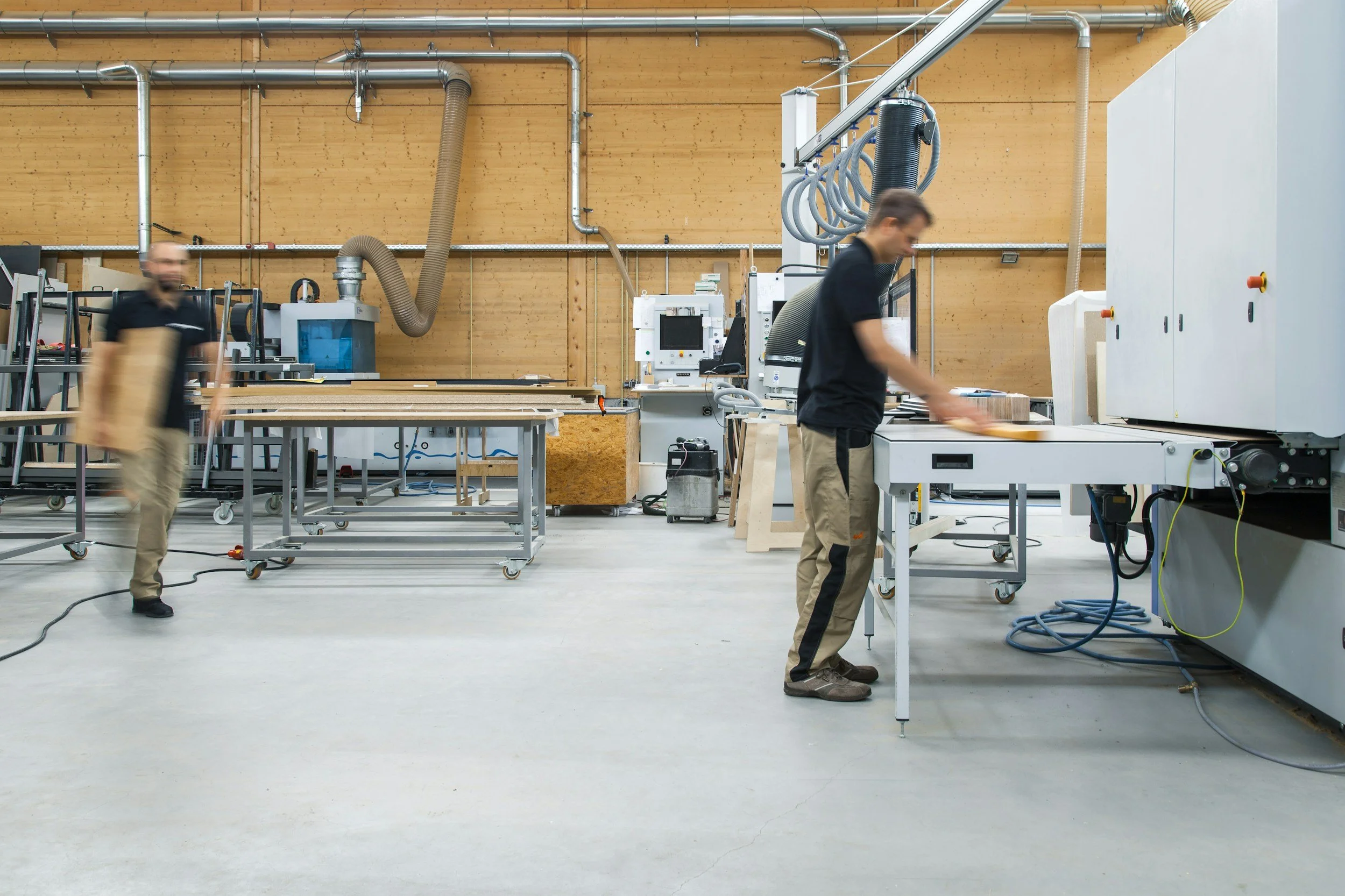 Medewerkers aan het werk in onze professionele textielproductieruimte in Utrecht, uitgerust met hoogwaardige machines voor kwalitatieve bedrijfskleding.
