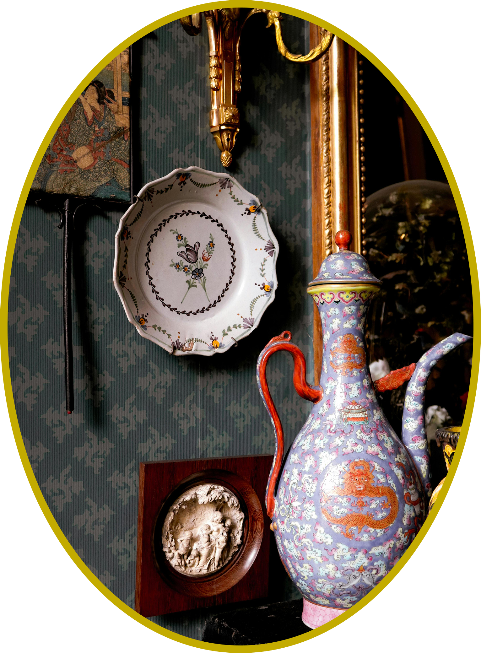 Curated maximalist vignette with hand-painted porcelain vase, decorative plate, and antique wall art