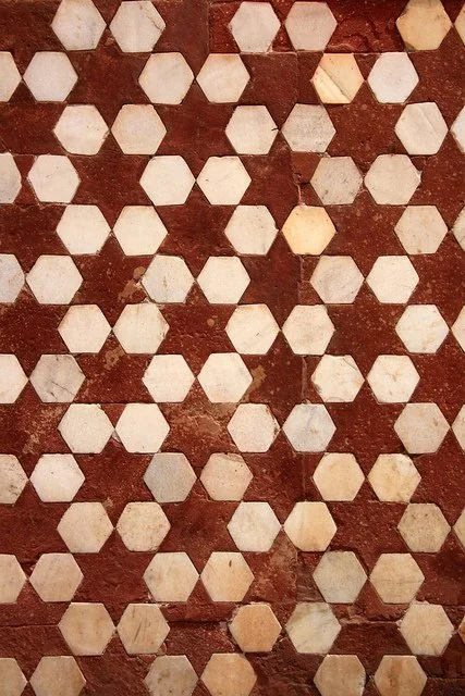 Patterned floor with red and white hexagonal tiles arranged in a repeating pattern.