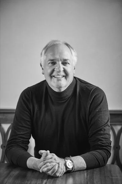 Paul Polman, former CEO of Unilever, and advisor to NatureProsperity. A smiling middle-aged man with gray hair wearing a dark long-sleeve shirt, sitting at a table with hands clasped, in front of a plain background.