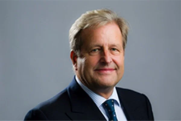 Stephen Brenninkmeijer, advisor to NatureProsperity. A middle-aged man with blonde hair wearing a dark suit, light blue shirt, and dark tie, smiling against a plain gray background.