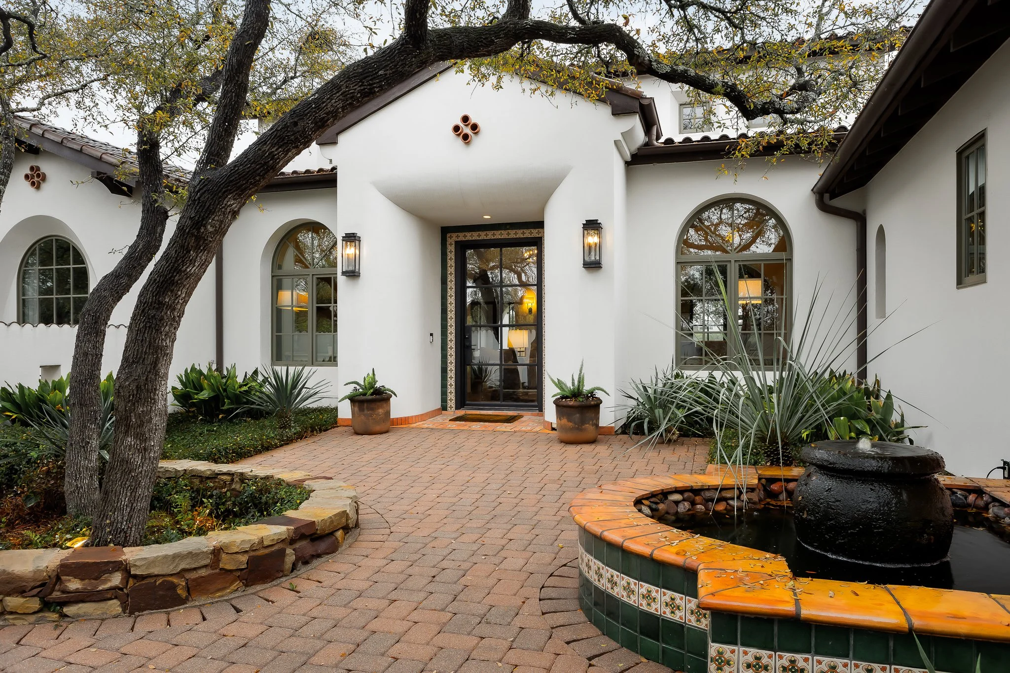 Breathtaking exterior of a warm, architecturally refined estate at 4500 Spanish Oaks, nestled within the gates of Spanish Oaks on nearly an acre with sweeping, unobstructed views across a private ranch - where natural textures, resort-style grounds, 