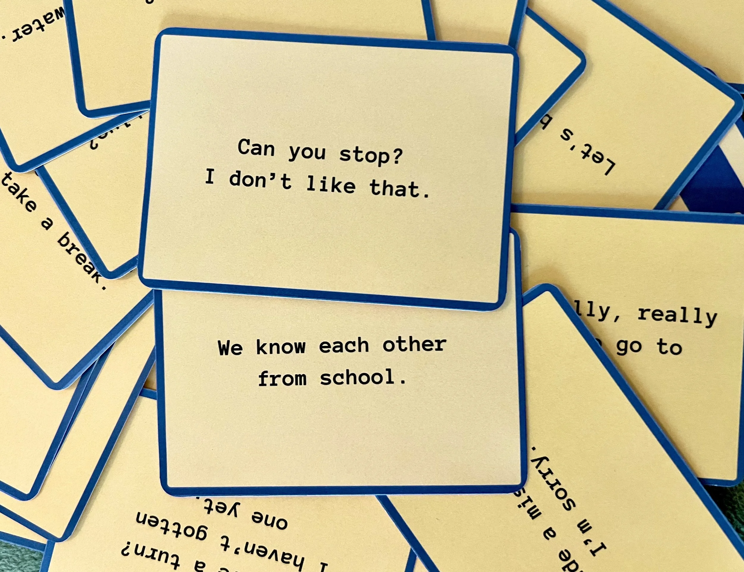 A close-up of multiple yellow cards with blue borders, with some text visible on one card that reads, "Can you stop? I don’t like that."