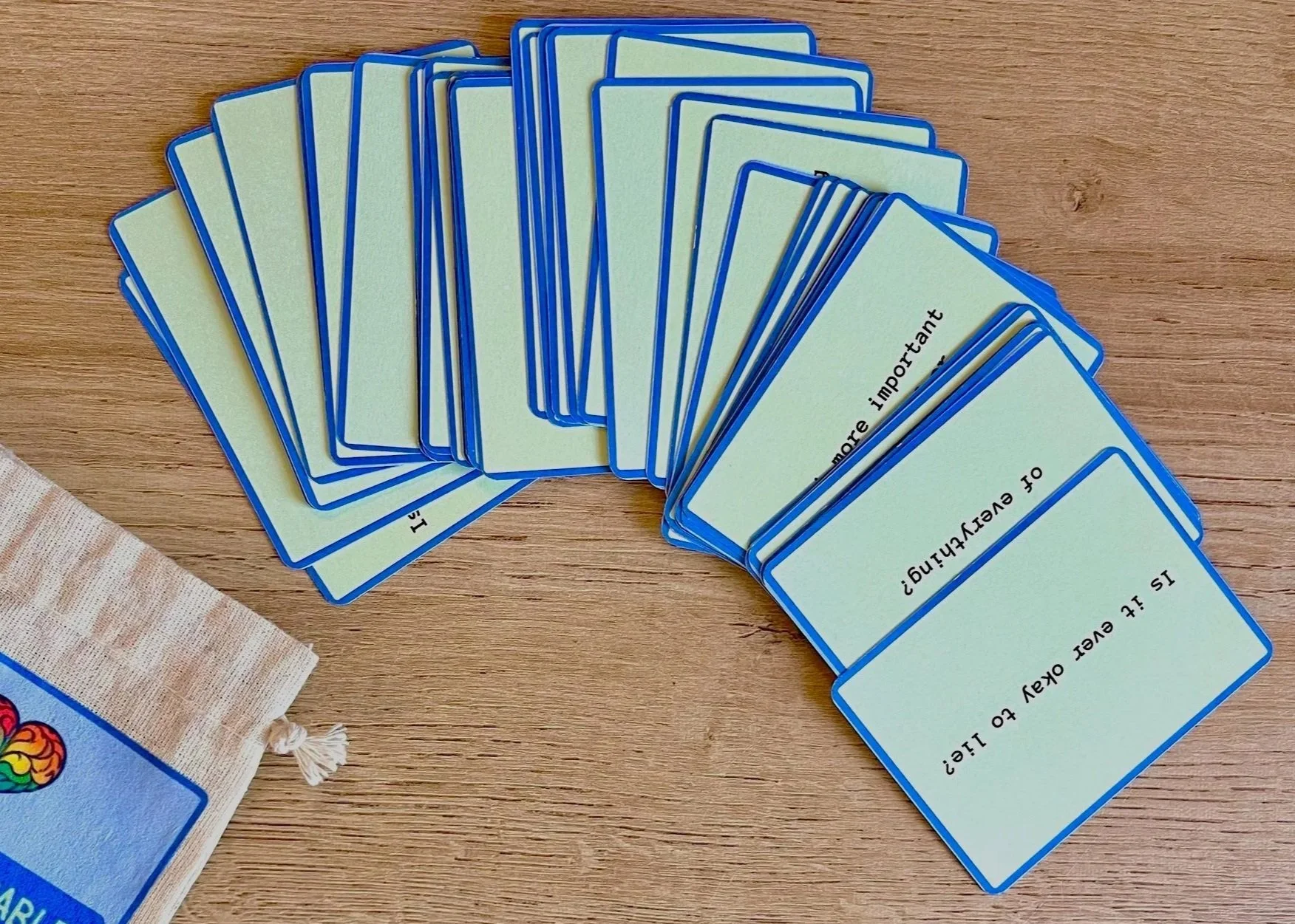 Set of yellow flashcards with questions about evaluating and giving advice, spread out on a wooden surface.