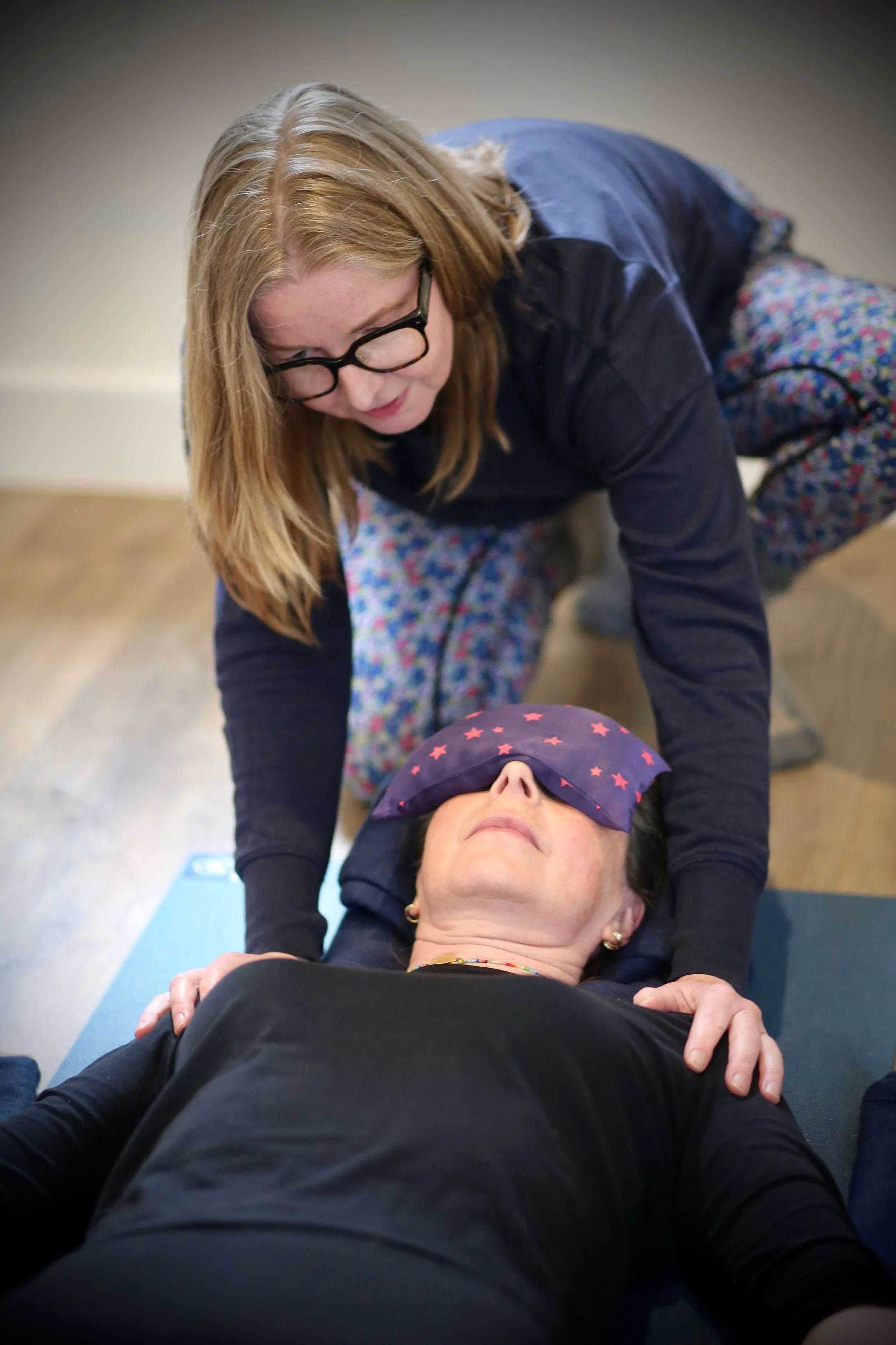 Catriona of Little Barn Yoga is assisting on a yoga mat