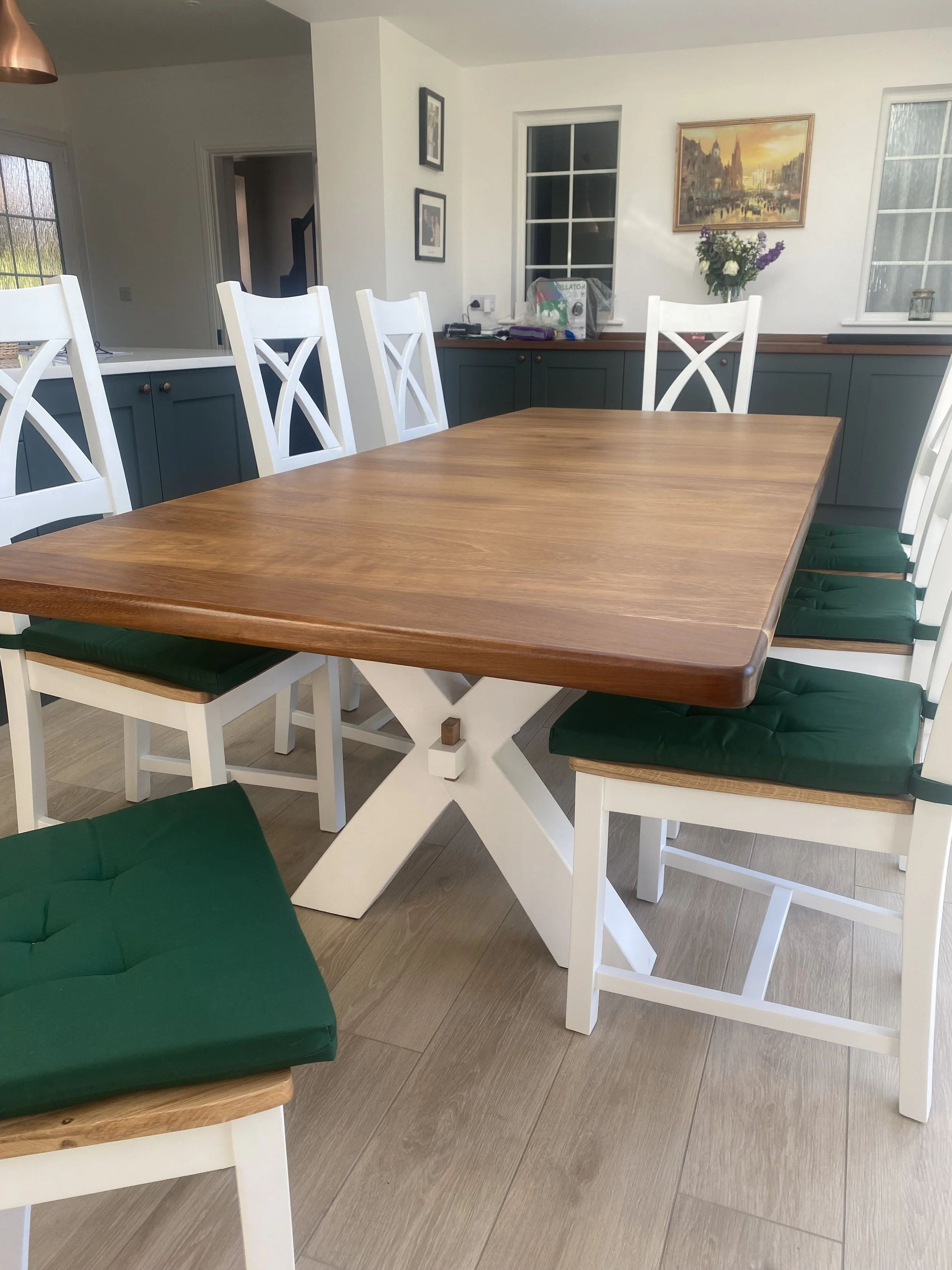 Dining table in iroko with curved x shaped base