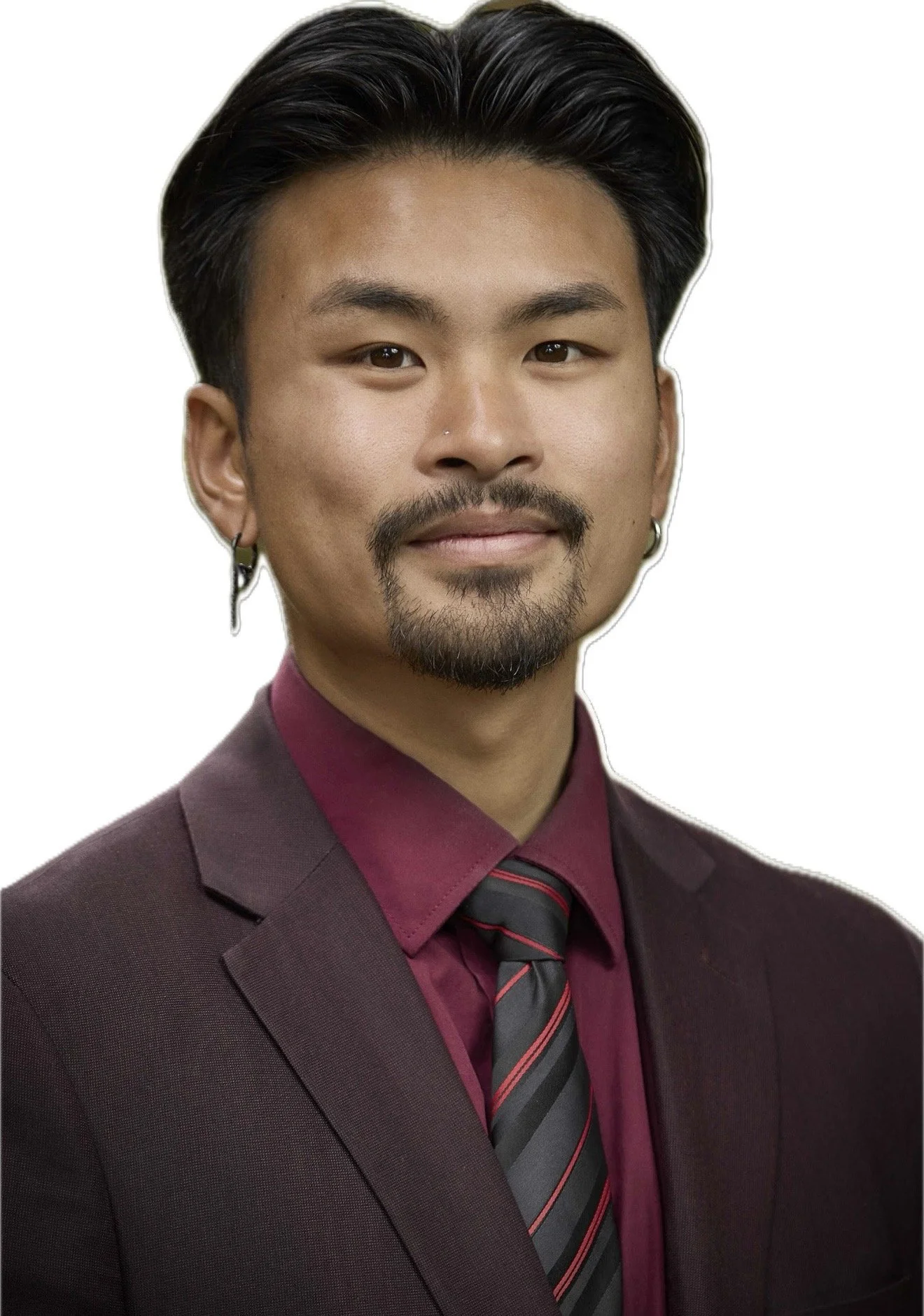 A professional man with dark hair, beard, and earrings wearing a maroon suit, maroon shirt, and striped tie against a white background.