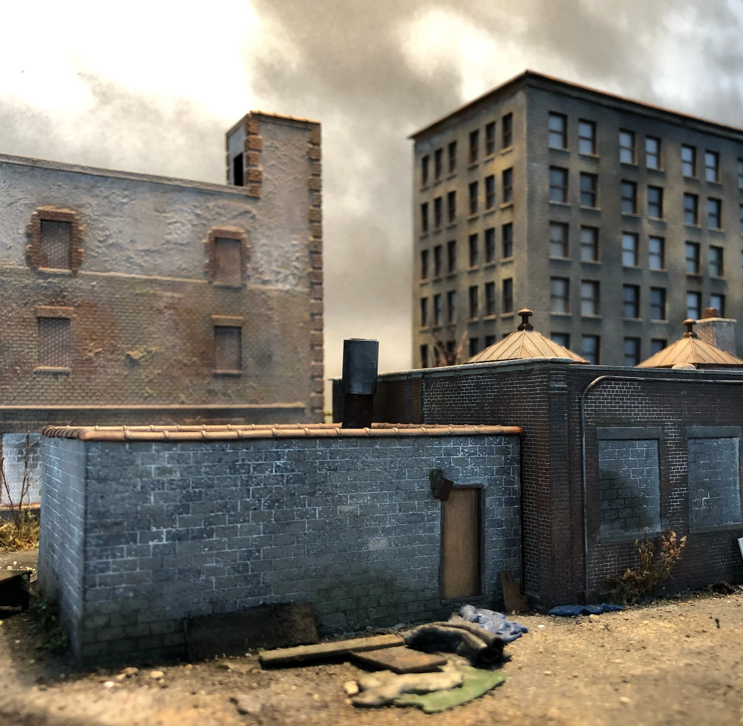 Diorama of city buildings with realistic textures and window details, set outdoors with a cloudy sky in the background.
