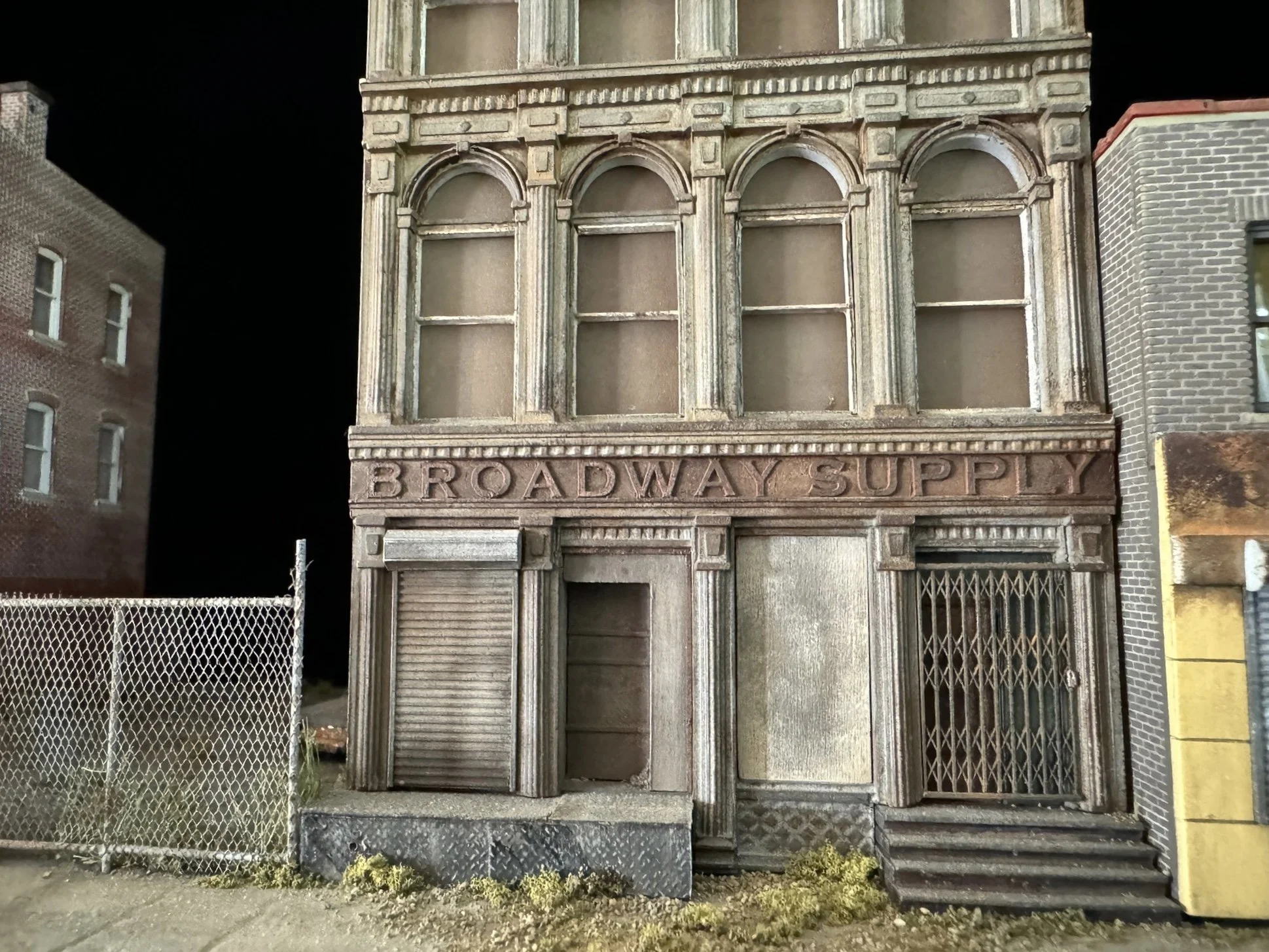 Old building facade with boarded-up windows and a sign that reads 'Broadway Supply' at the bottom.