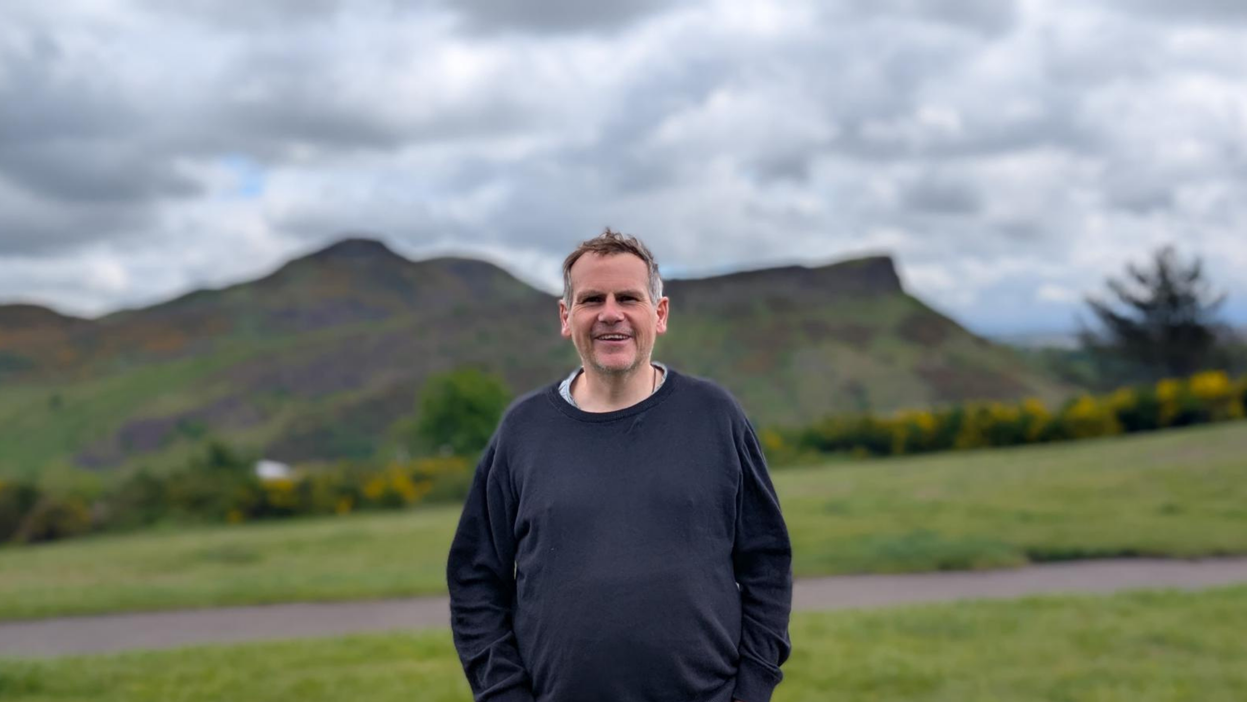 Jim in Edinburgh with Arthurs Seat in the background
