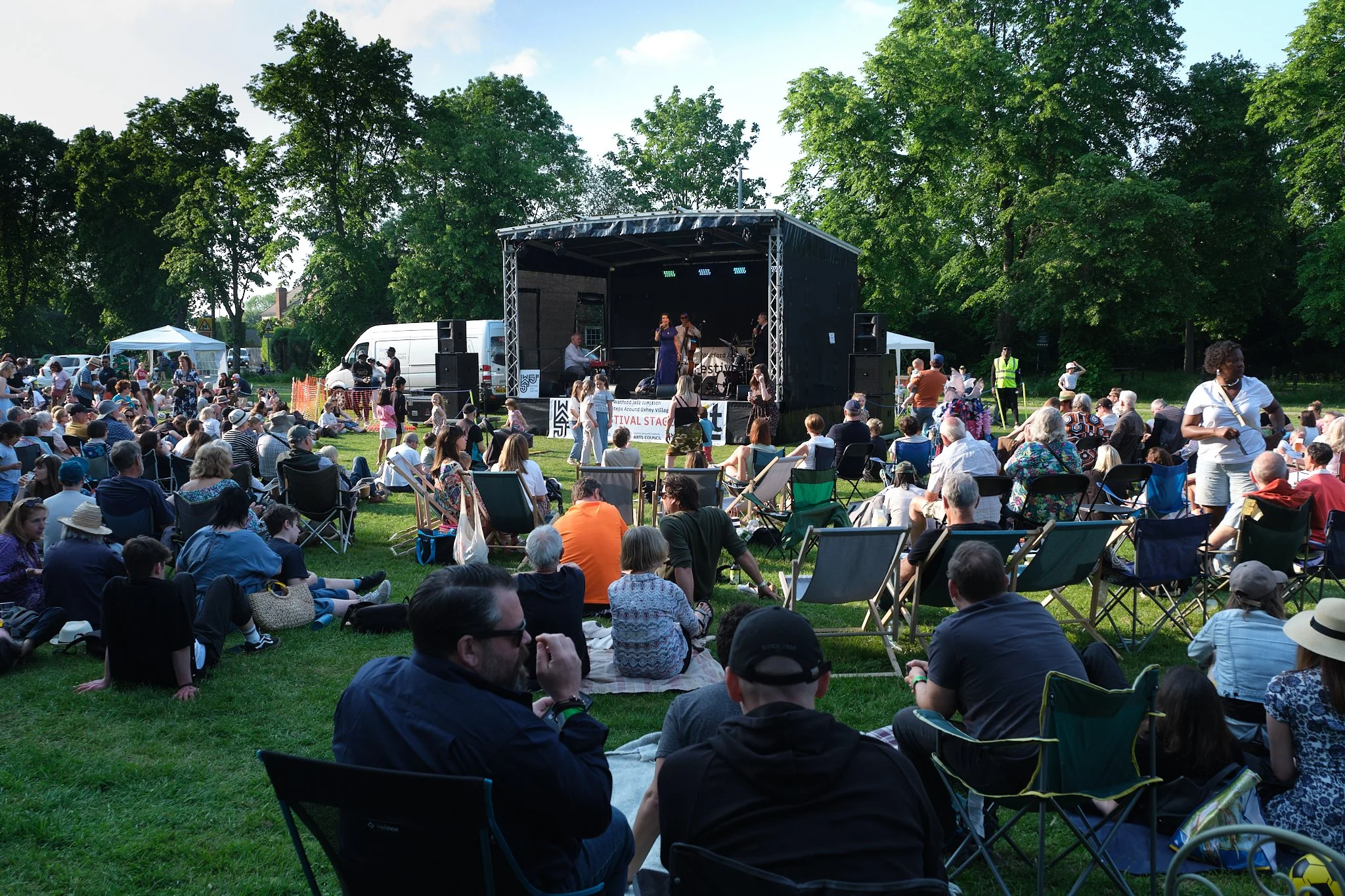 An audience gathering on a Watford village green to hear the Ronnie Scott's All Stars fronted by Emma Smith as part of our Jazz Steps events.