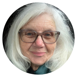 Retired Linfield Librarian Jean Caspers, with long white hair wearing glasses, smiling slightly.