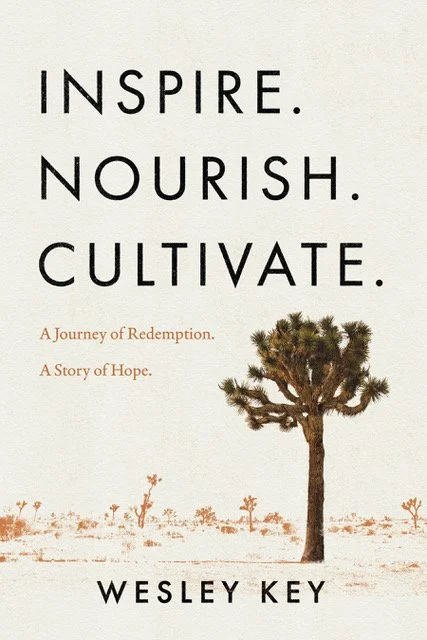 Book cover with the words "INSPIRE. NOURISH. CULTIVATE." by Wesley Key, featuring a desert scene with a tree and smaller trees in the background, with the subtitles "A Journey of Redemption. A Story of Hope."