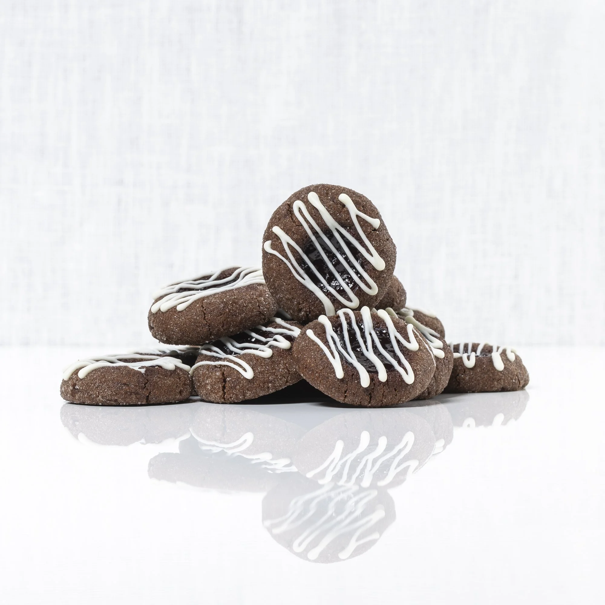 Chocolate Raspberry Thumbprint Cookies - 

Our mouthwatering chocolate thumbprints are filled with seedless raspberry jam and finished with a drizzle of white chocolate. A decadent little treat!

$10/dozen