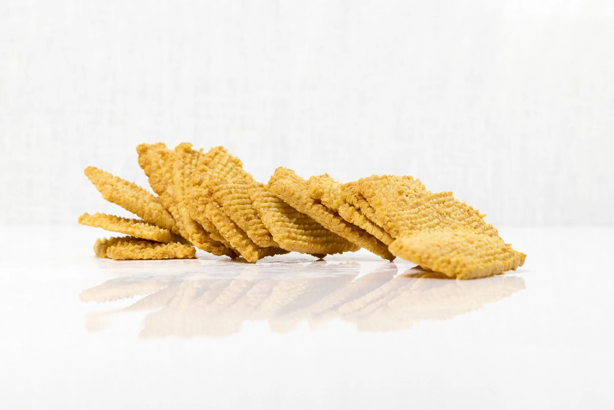 Cheese Straws - 

Our version of this classic Southern snack, with the emphasis on cheese. Made with a quality extra-sharp cheddar, these little bites may look flat, but they pack a cheesy punch with just the right amount of afterbite. Pair with cock